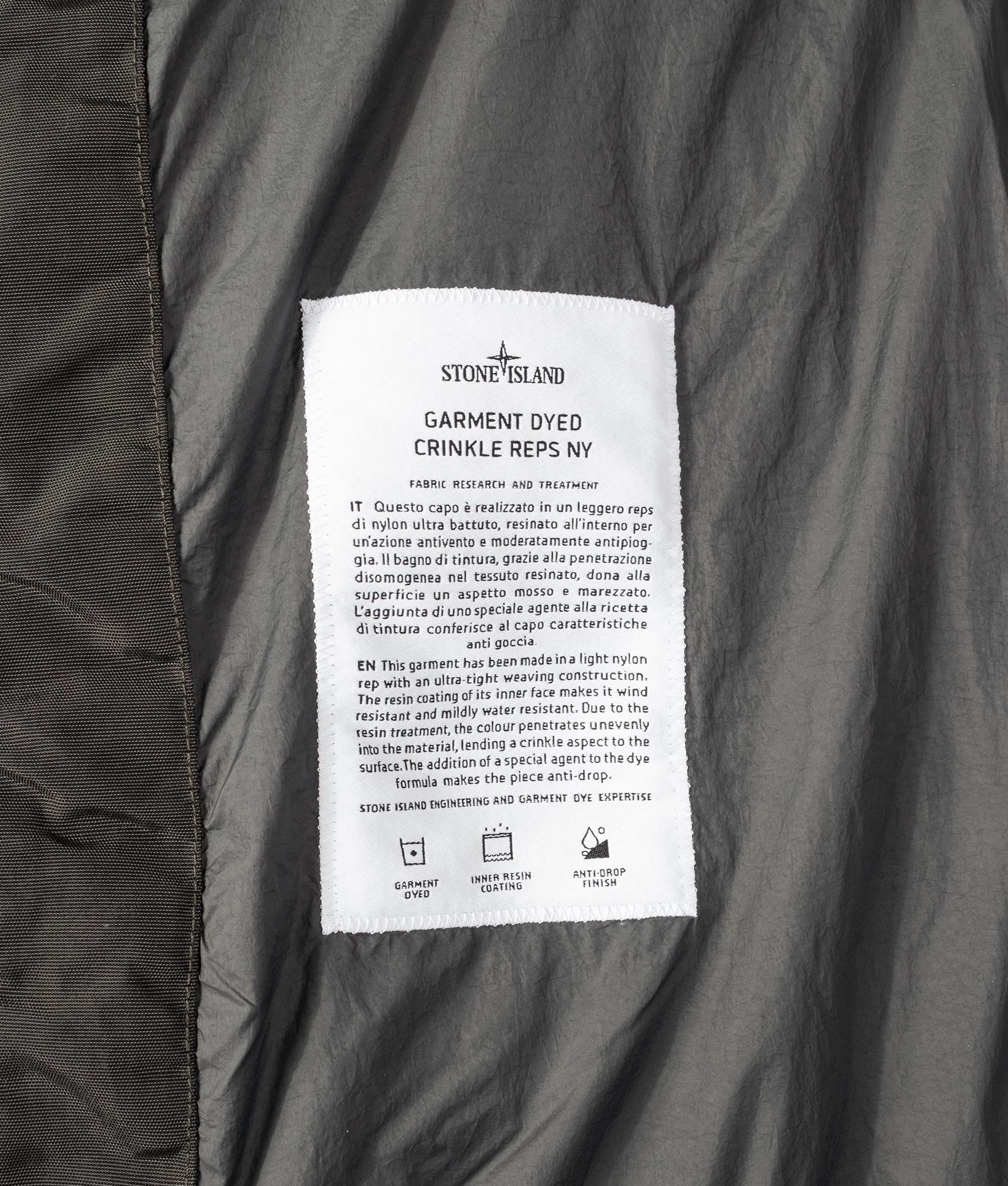 Stone Island Garment Dyed Crinkle Reps NY Down Jacket in Lead Grey at EQVVS Menswear. Label shot.
