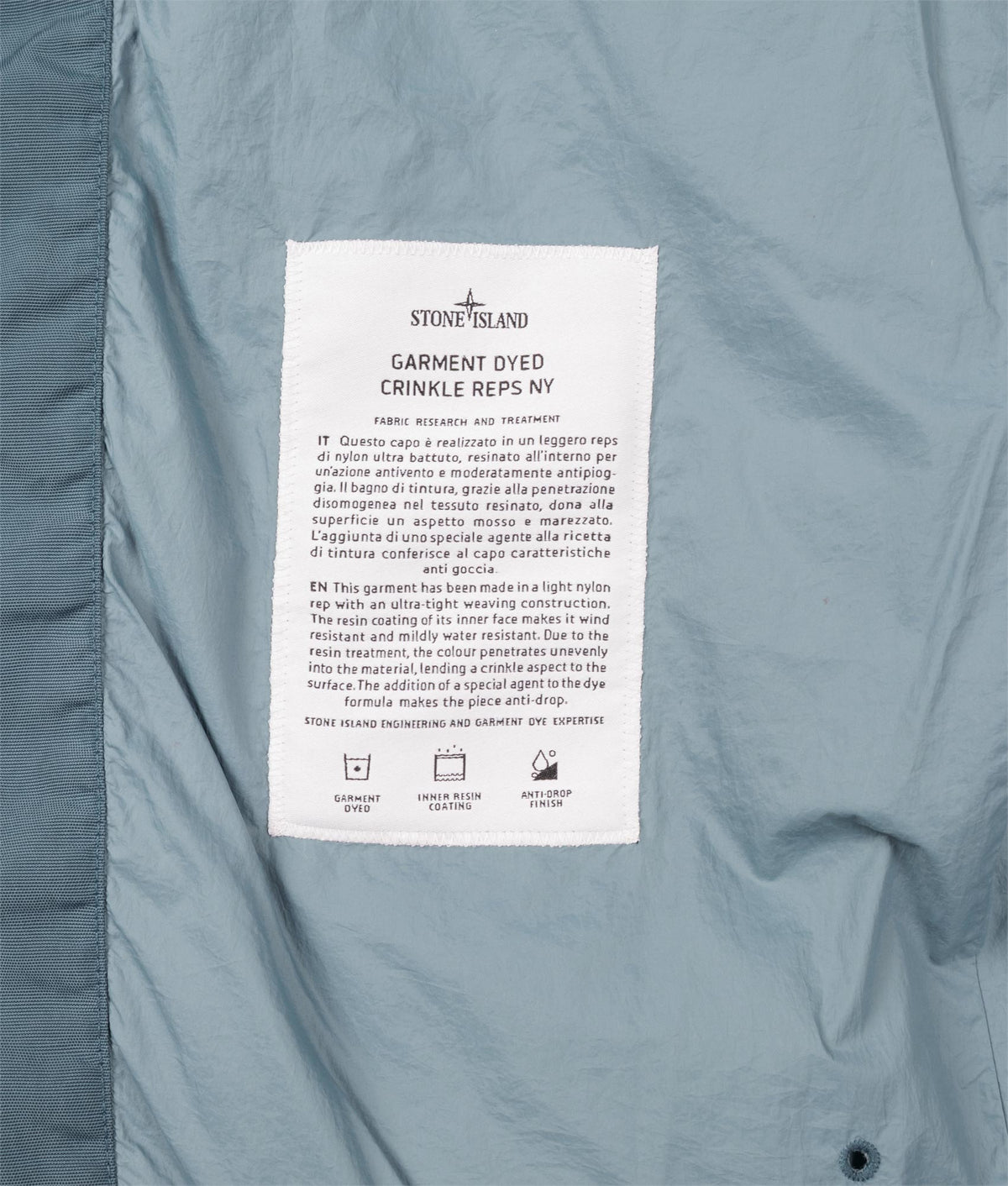 Stone Island Crinkle Reps NY Puffer Jacket in Steel Blue at EQVVS Menswear. Label shot.