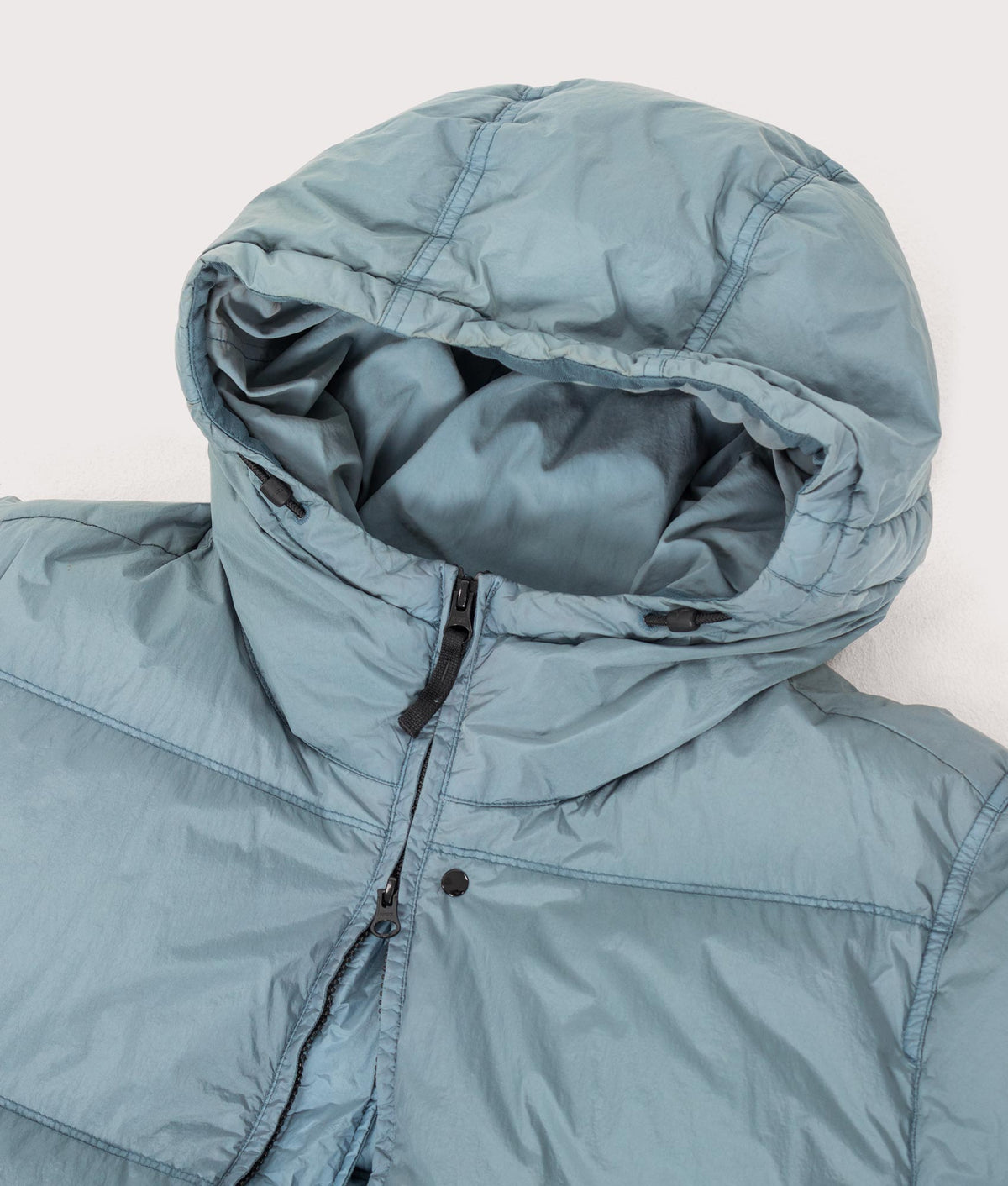 Stone Island Crinkle Reps NY Puffer Jacket in Steel Blue at EQVVS Menswear. Hood shot.