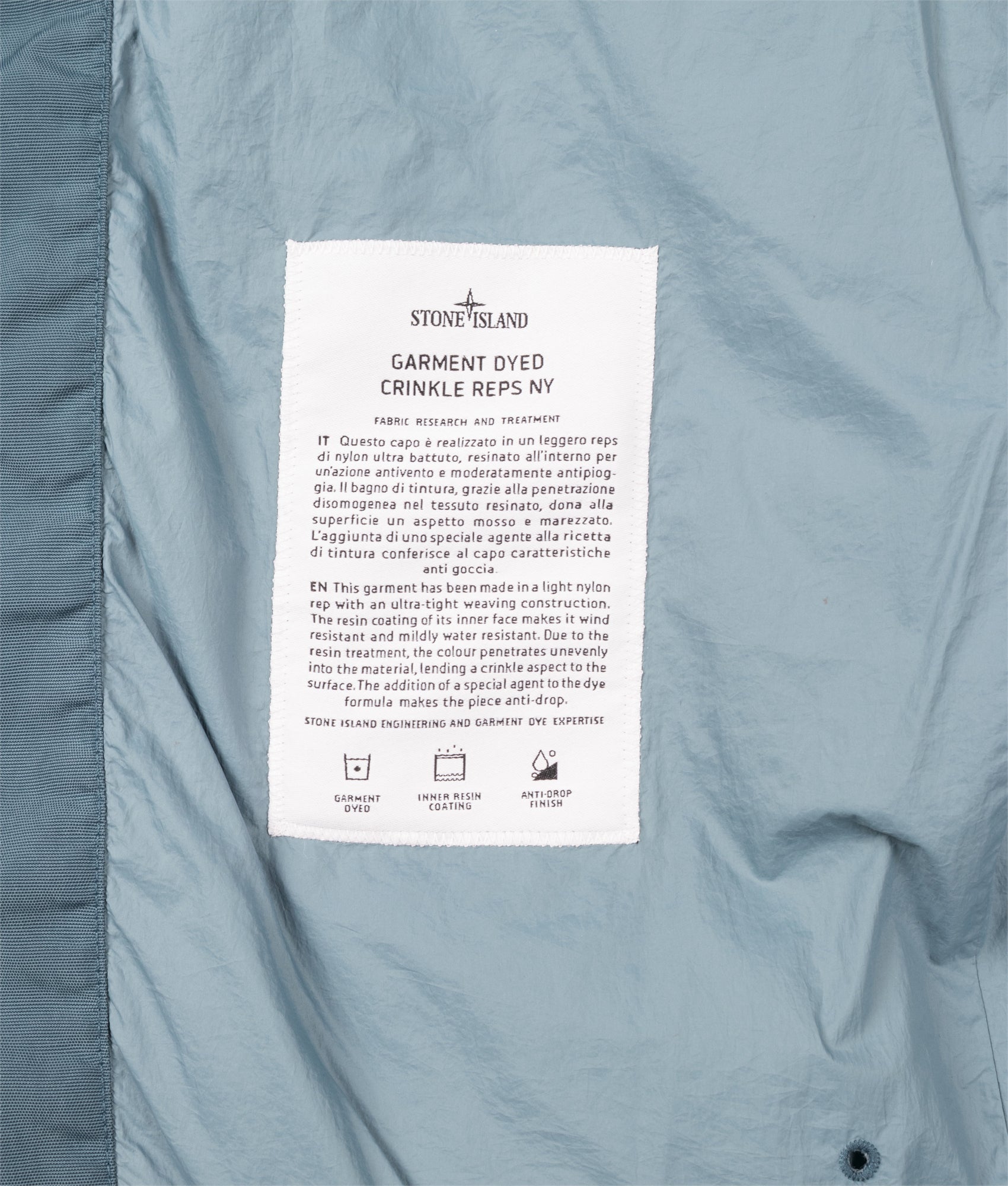 Stone Island Crinkle Reps NY Puffer Jacket in Steel Blue at EQVVS Menswear. Label shot.