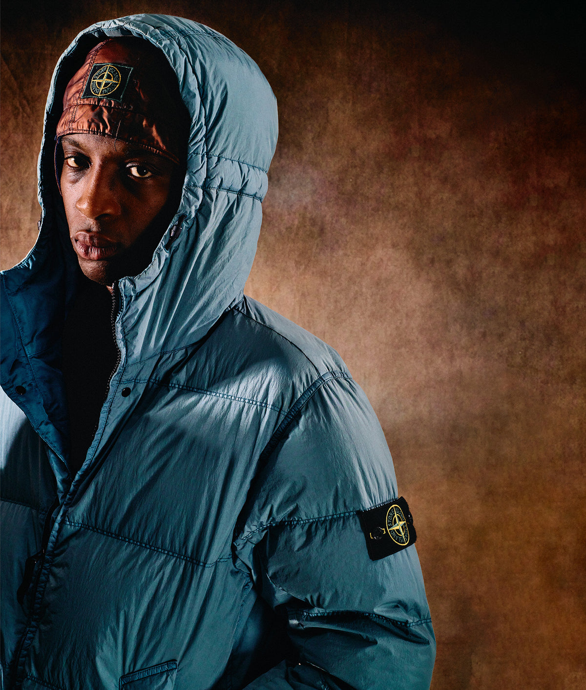 Stone Island Crinkle Reps NY Puffer Jacket in Steel Blue at EQVVS Menswear. Campaign shot.