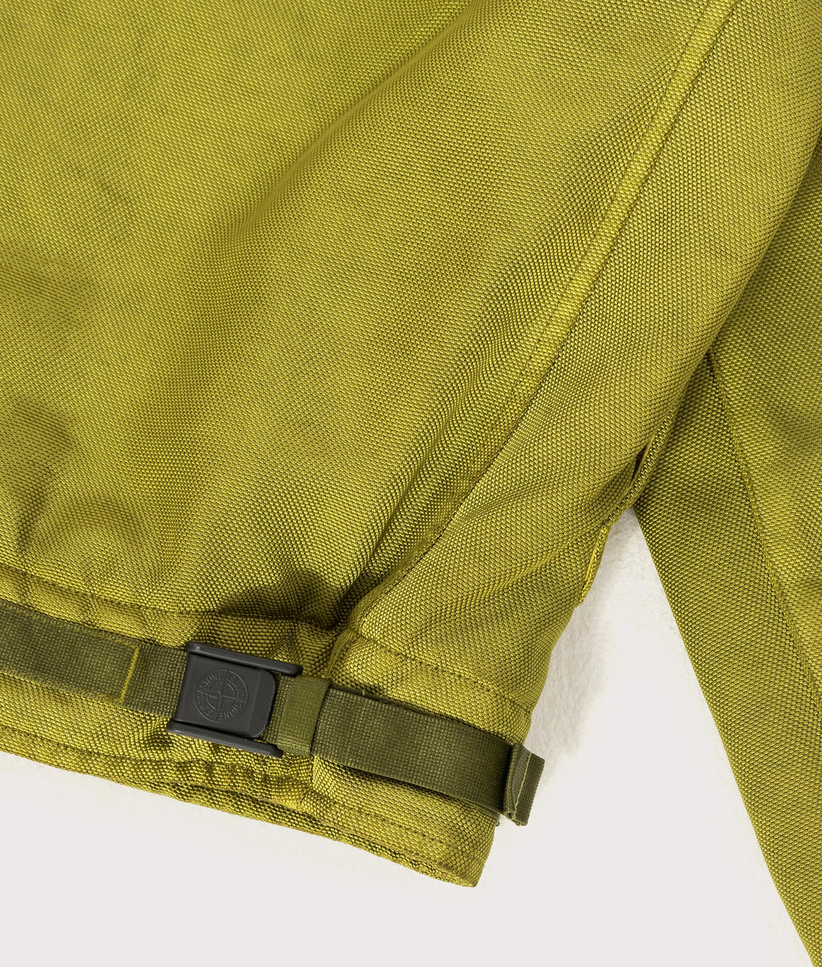 Stone Island Dense Oxford Nylon-TC Jacket in Cactus at EQVVS Menswear. Waist buckle shot.