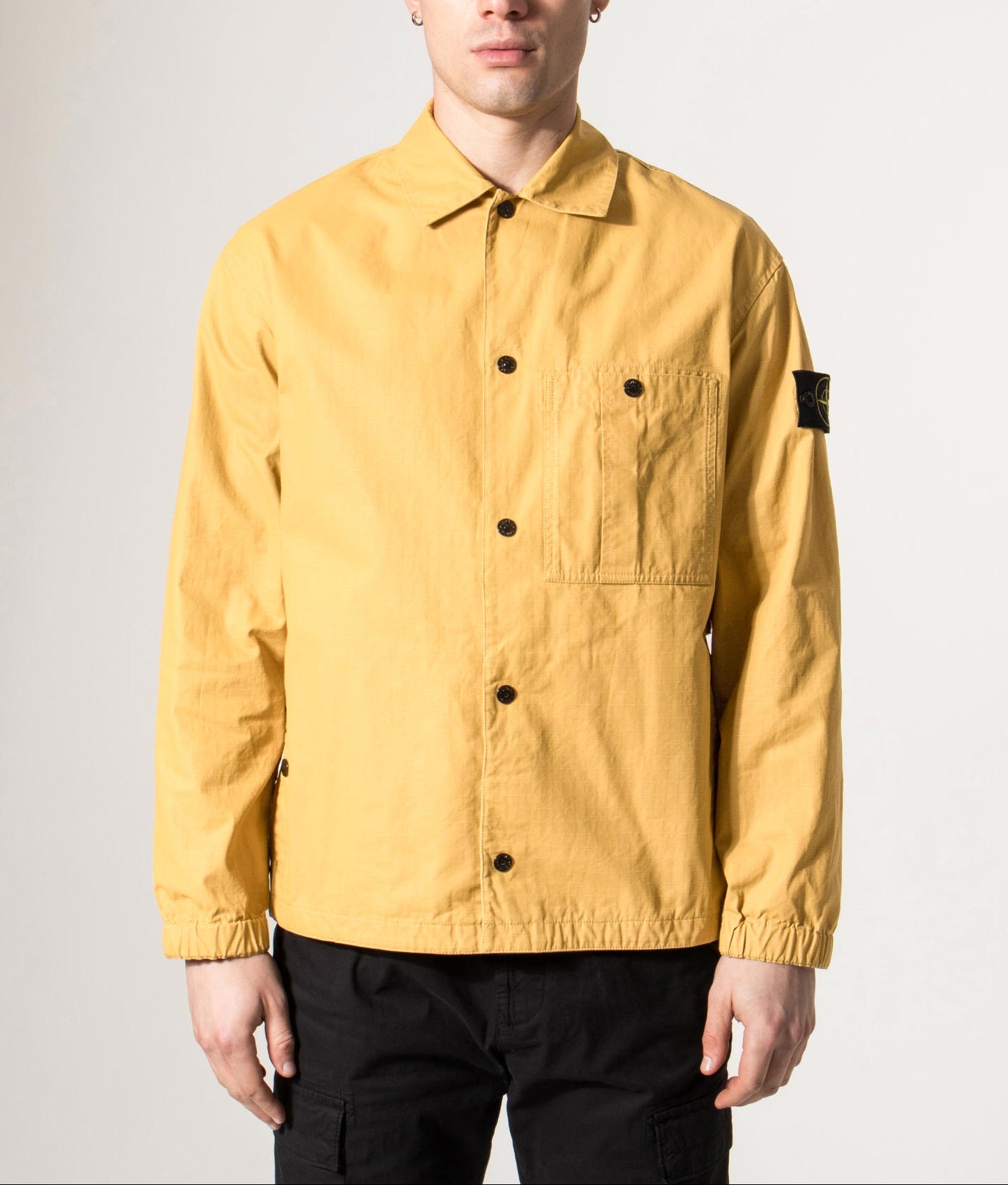 Stone Island Relaxed Fit Double Coated Cotton Ripstop Overshirt in Mustard at EQVVS Menswear. Model front shot.