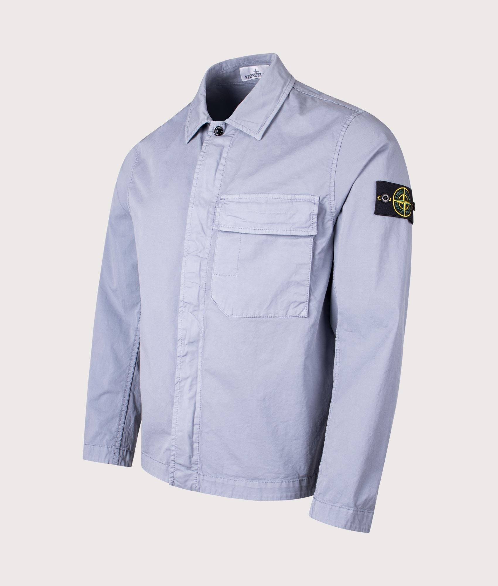 Stone Island Stretch Organic Cotton Twill Overshirt in Avio Blue at EQVVS Menswear. Angled front shot.