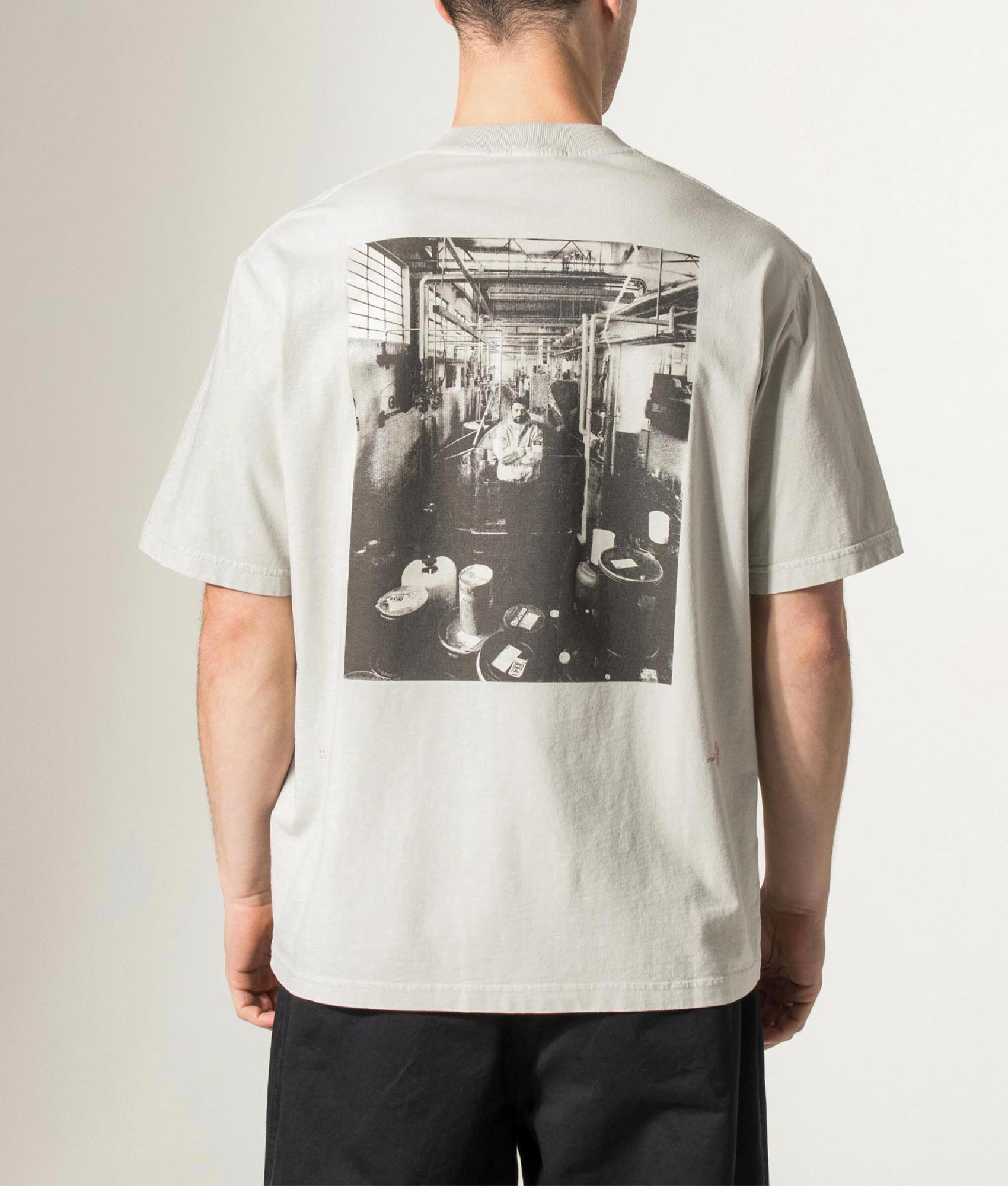 Stone island Carlo Rivetti T-Shirt in Pearl Grey at EQVVS Menswear. Model Back shot.