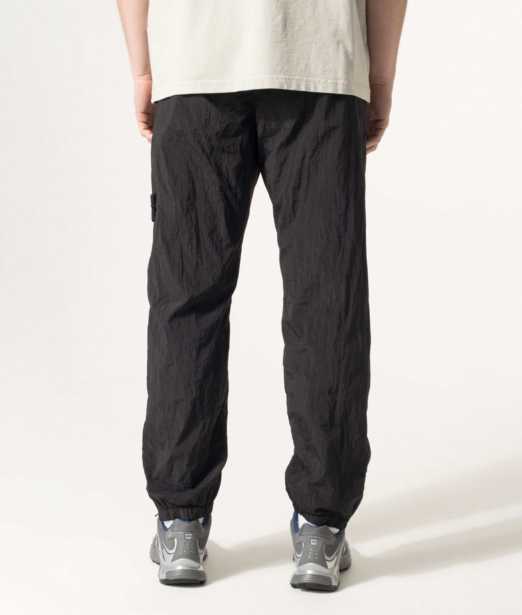 Stone Island Nylon Metal in Econyl® Trousers in Black at EQVVS Menswear. Model back shot.
