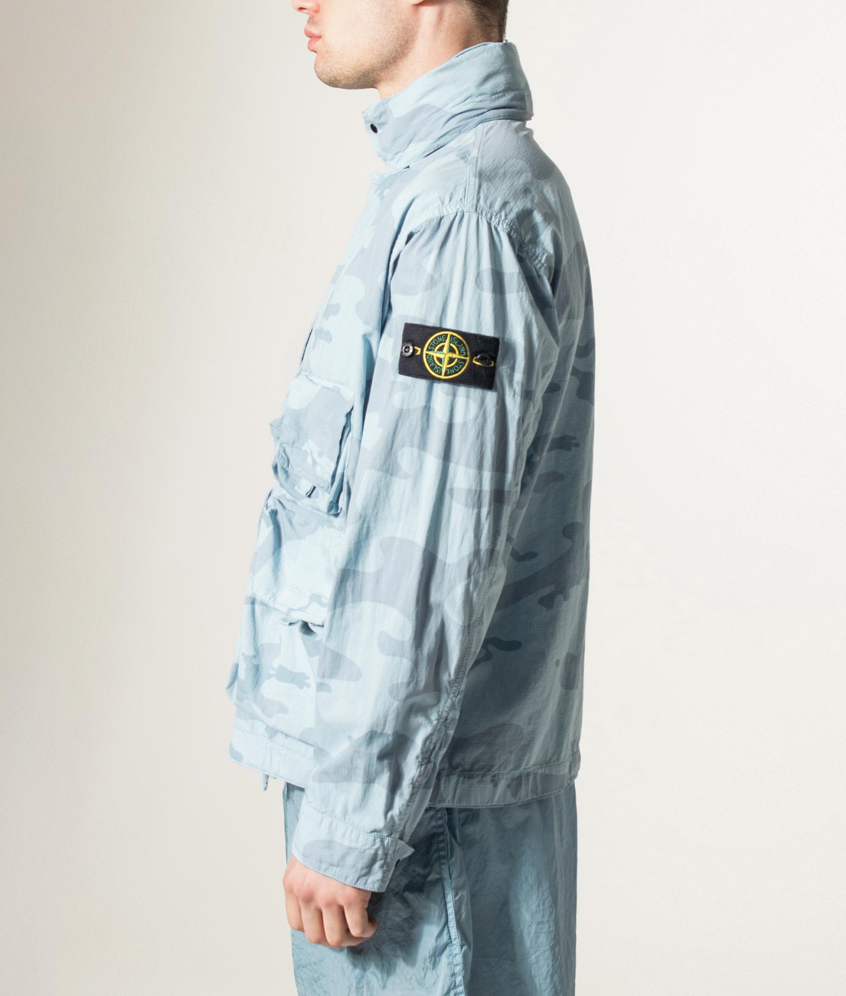 Stone Island Faded Camo Light Ripstop-OVD Field Jacket in Powder Blue at EQVVS Menswear. Model detail shot.