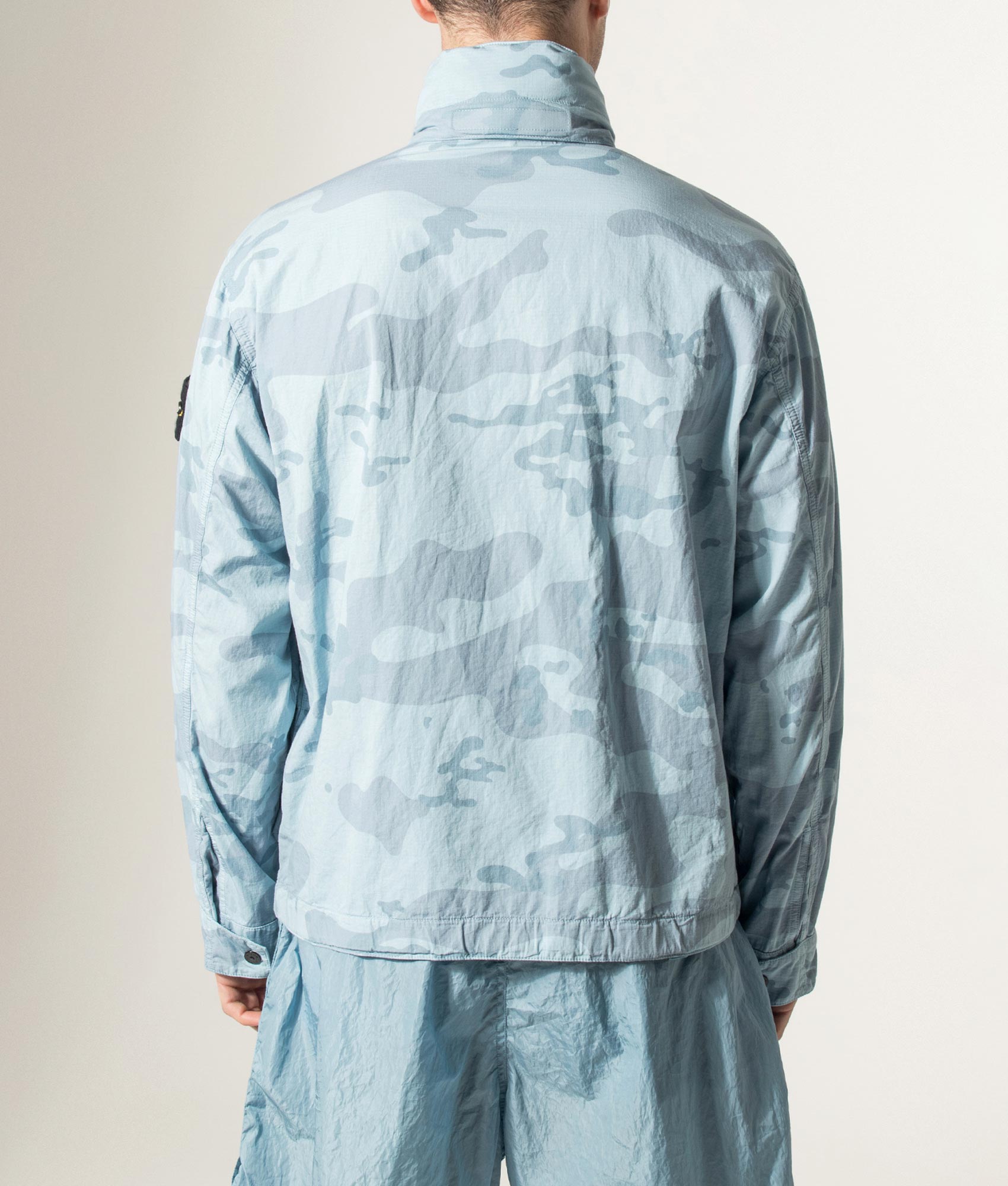 Stone Island Faded Camo Light Ripstop-OVD Field Jacket in Powder Blue at EQVVS Menswear. Model back shot.