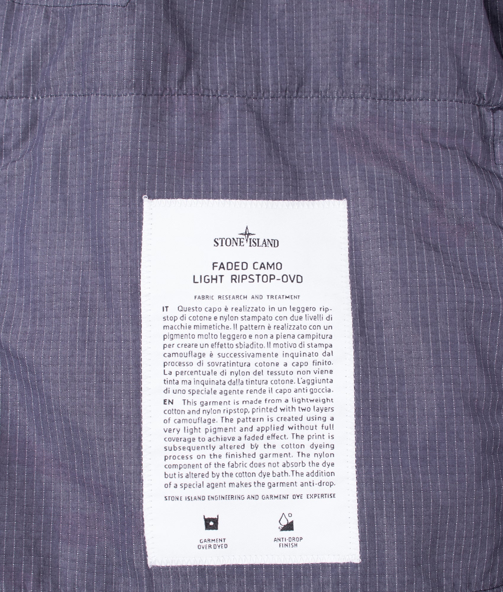 Stone Island Faded Camo Light Ripstop-OVD Field Jacket in Blue Grey at EQVVS Menswear. Label shot.
