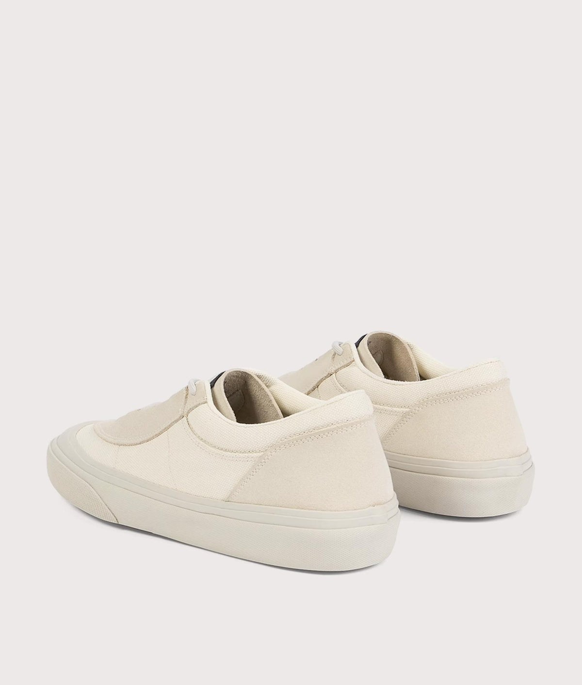 Stone Island Canvas Suede Low Top Trainers in Ivory at EQVVS Menswear. Angled back shot.