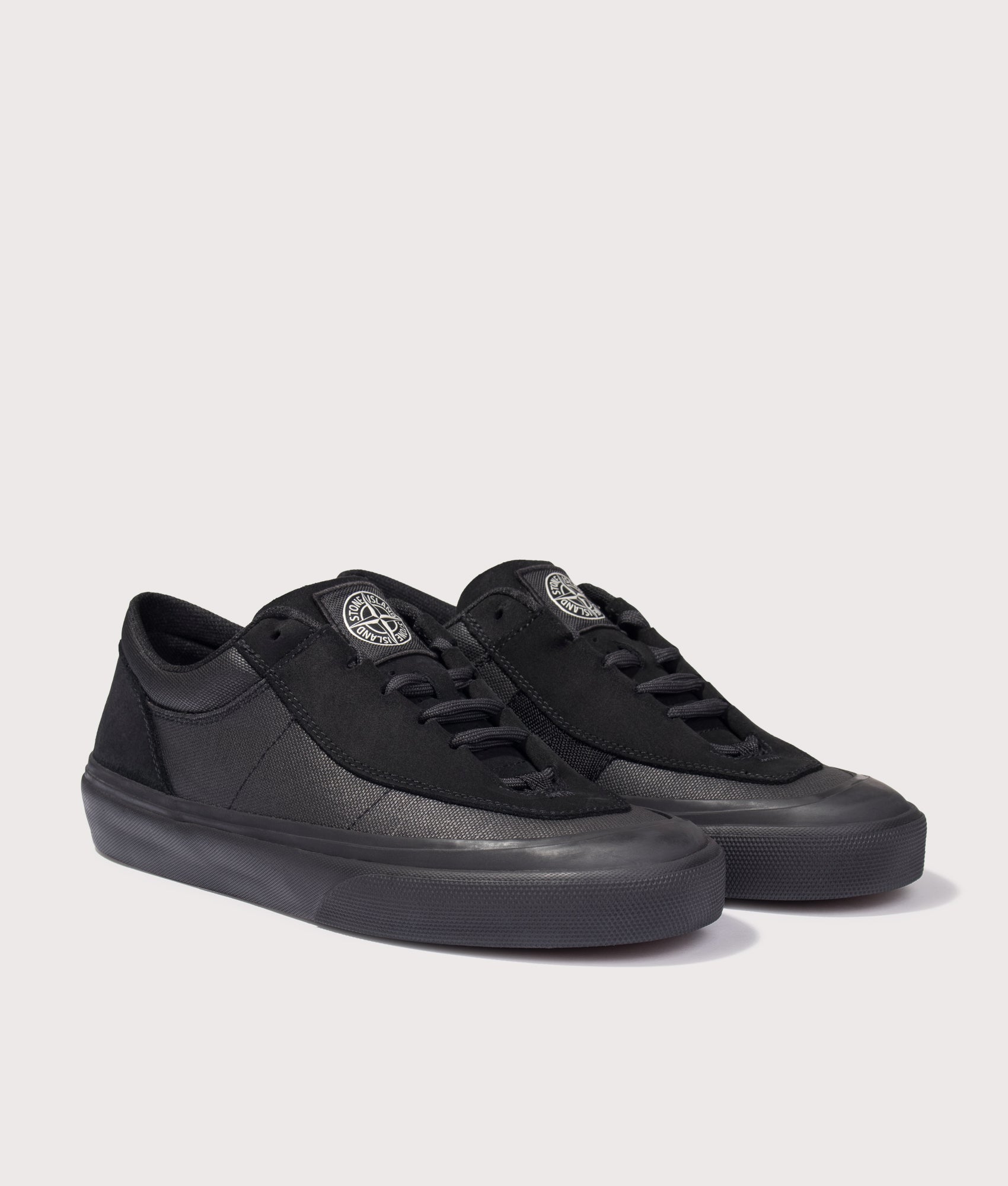 Stone Island Canvas Suede Low Top Trainers in Black at EQVVS Menswear. Angled front shot.
