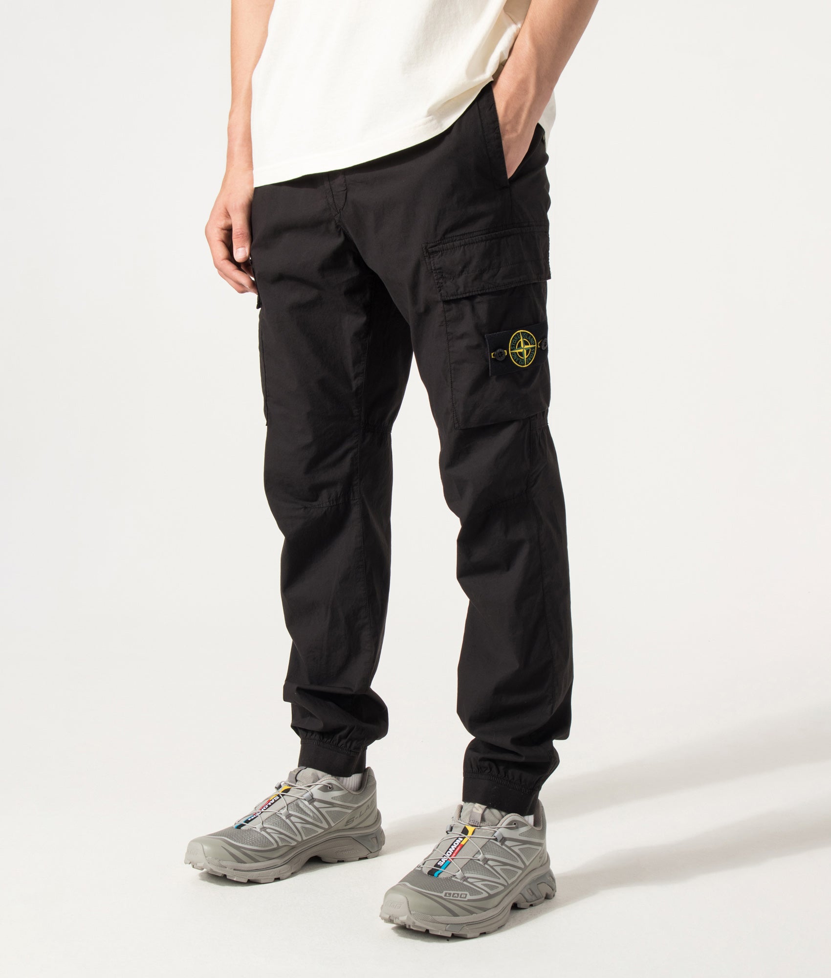 Stone Island Regular Tapered Fit Cargo Pants in Black at EQVVS Menswear. Angled model front shot.