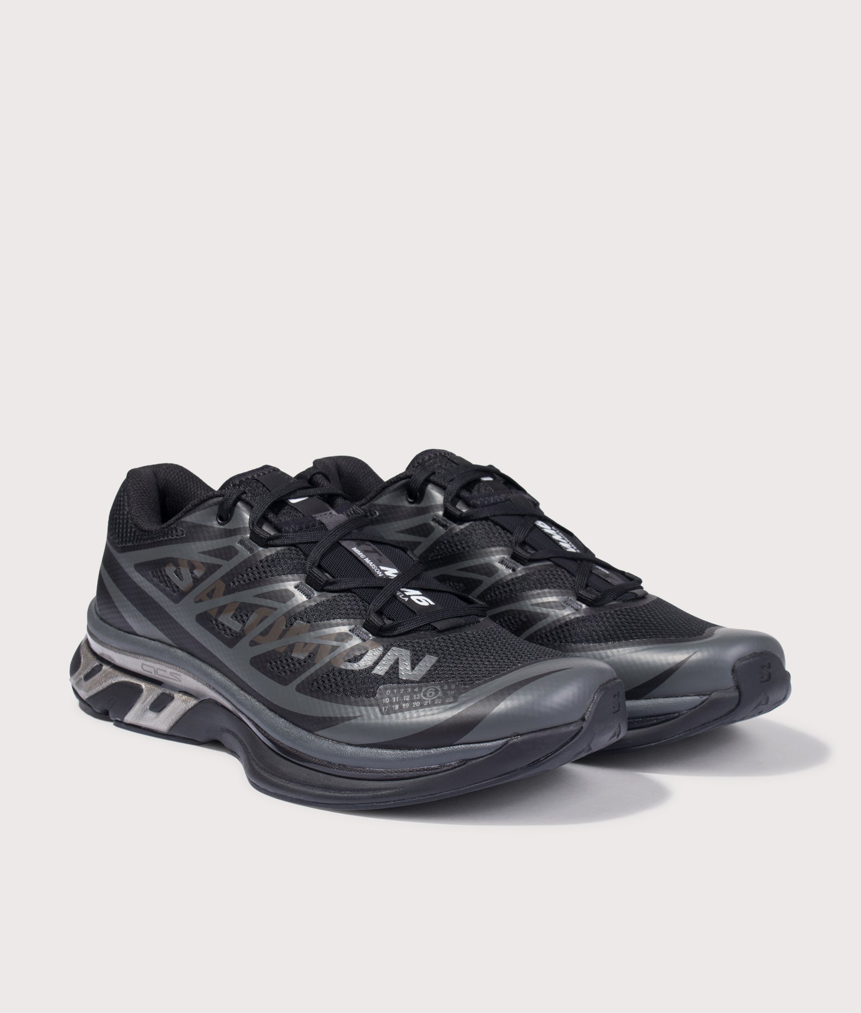 MM6 X Salomon XT Sneakers in Black/Black/Asphalt by MM6 Maison Margiela. Shot by EQVVS. Front angled shot.