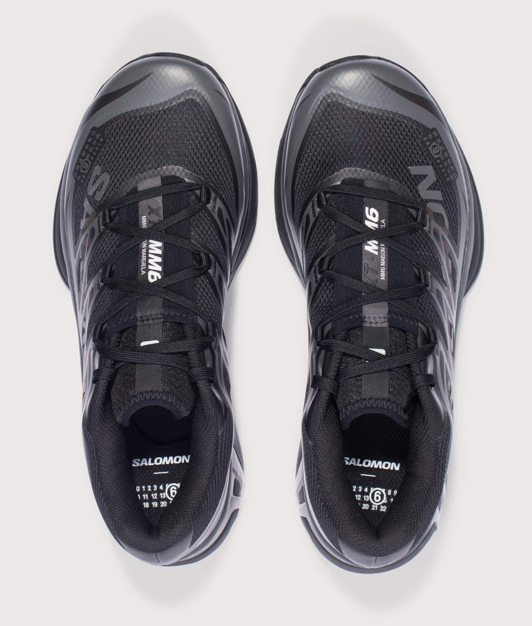 MM6 X Salomon XT Sneakers in Black/Black/Asphalt by MM6 Maison Margiela. Shot by EQVVS. Arial shot.