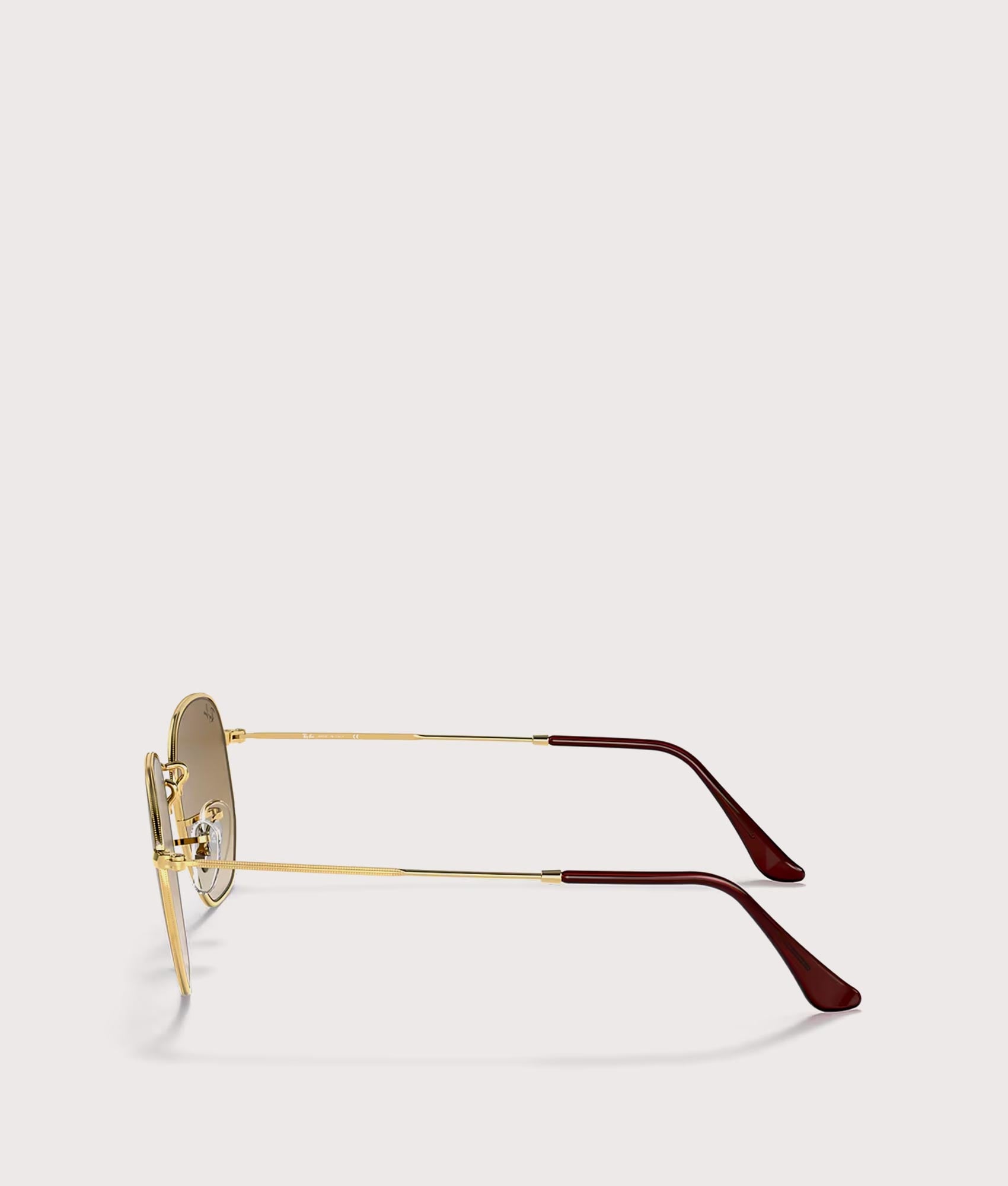 Hexagonal Flat Lens Sunglasses in Polished Arista Gold-Brown Lens by Ray-Ban. Shot by EQVVS. Side shot.