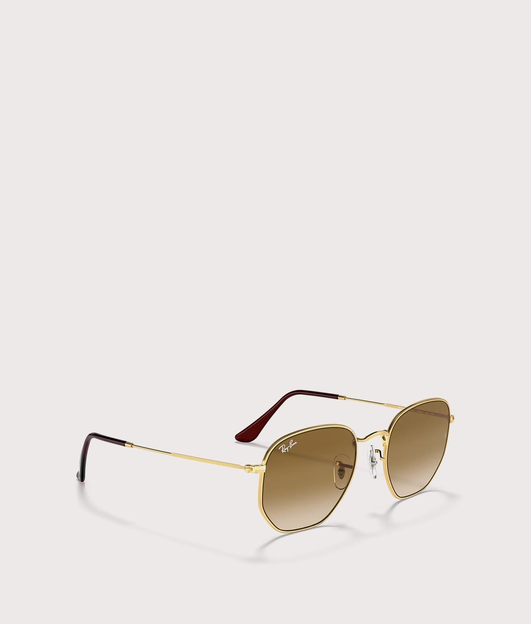Hexagonal Flat Lens Sunglasses in Polished Arista Gold-Brown Lens by Ray-Ban. Shot by EQVVS. Angled shot.