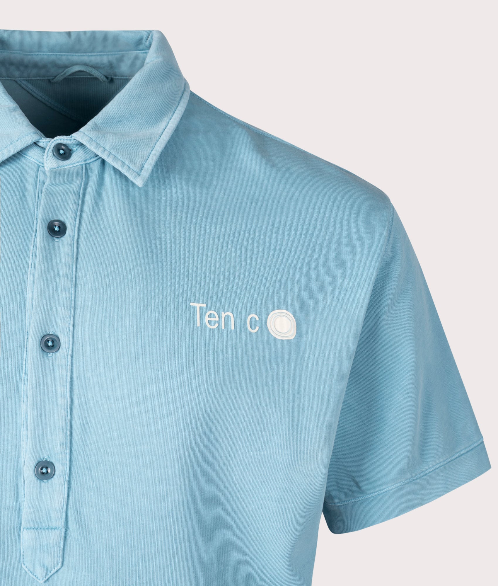 Ten c Mineral Garment Dyed Polo Shirt in Sky Blue Lake, 100% Cotton at EQVVS. Close-up shot.