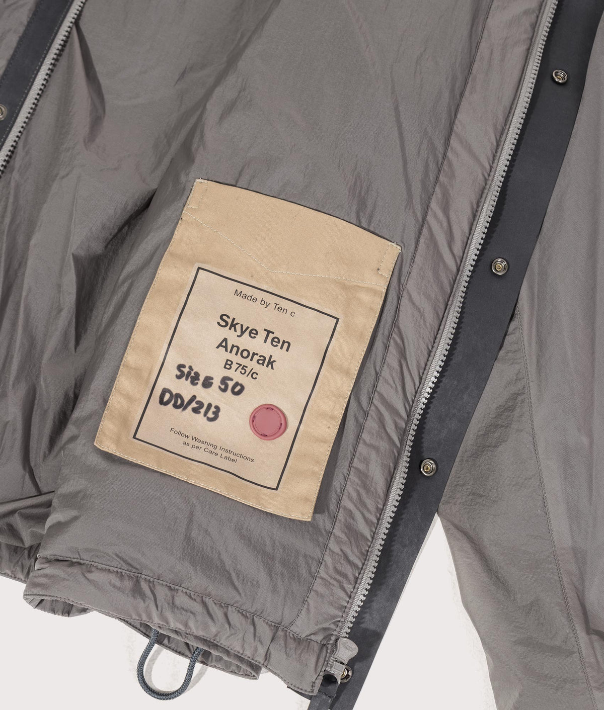 Lightly Padded Skye Ten Anorak Jacket by Ten c in Iron Grey. Shot by EQVVS. Inner label shot.