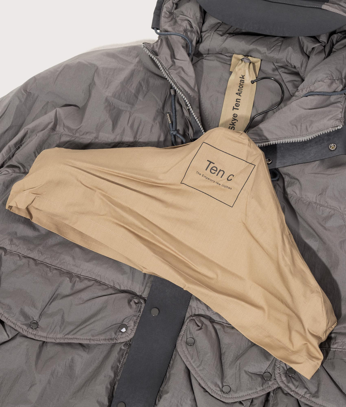 Lightly Padded Skye Ten Anorak Jacket by Ten c in Iron Grey. Shot by EQVVS. Branded hanger shot.