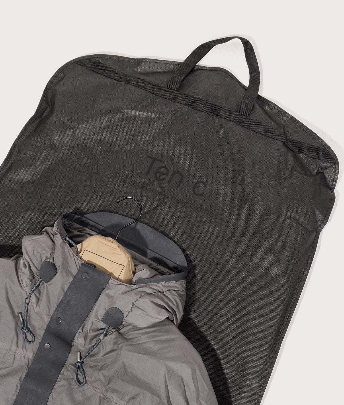Lightly Padded Skye Ten Anorak Jacket by Ten c in Iron Grey. Shot by EQVVS. Dust bag shot.