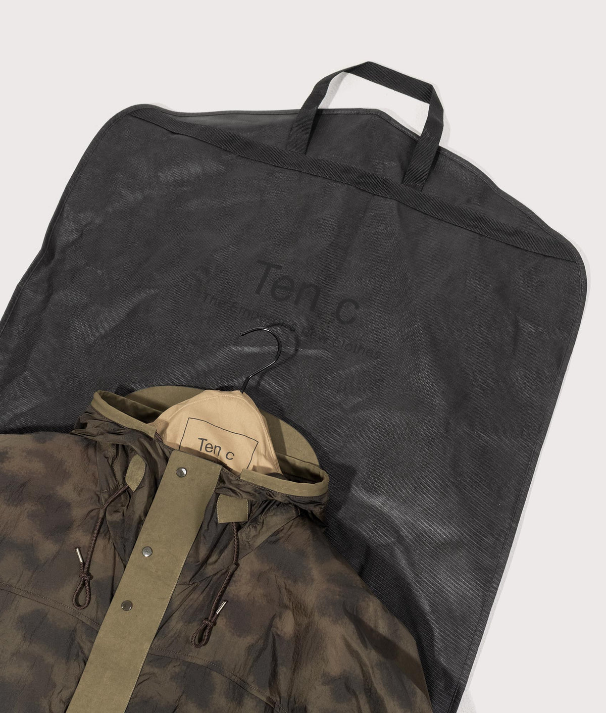 Camou Skye Ten Anorak Jacket by Ten c in Olive Green Shot by EQVVS. Dust bag shot.