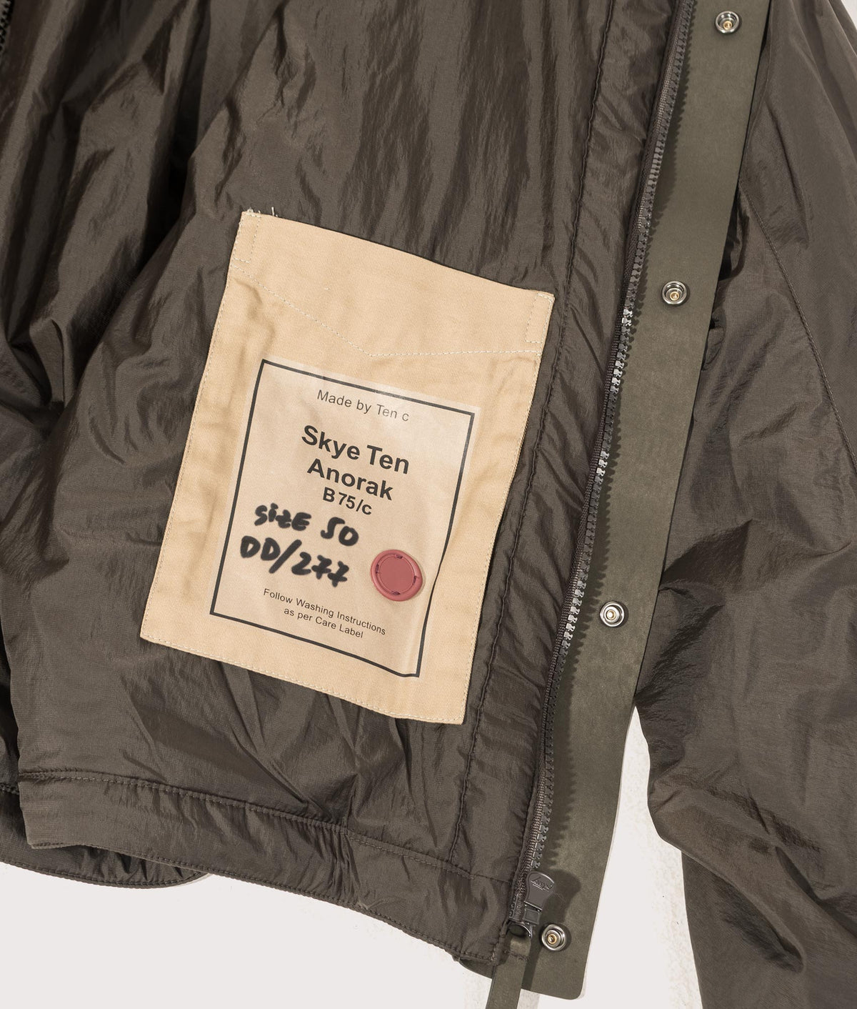 Lightly Padded Skye Ten Anorak Jacket by Ten c in Green Lizard. Shot by EQVVS. Inner label shot.