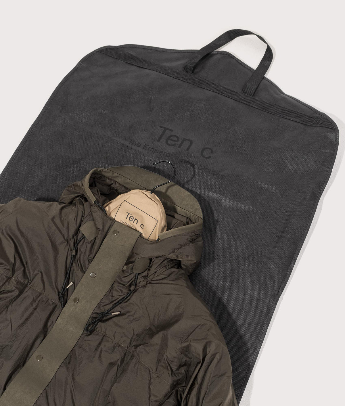 Lightly Padded Skye Ten Anorak Jacket by Ten c in Green Lizard. Shot by EQVVS. Dust bag shot.