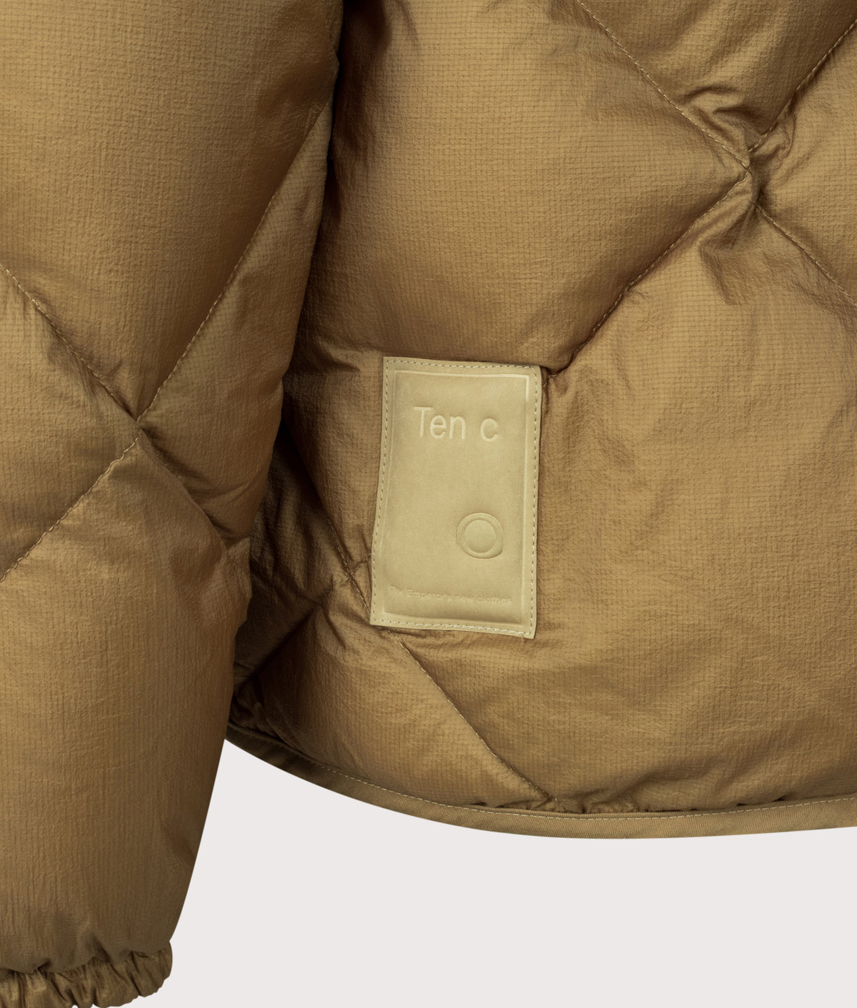 Ten c Izumo Down Liner Jacket in Cumin Brown at EQVVS Menswear. Detail shot.