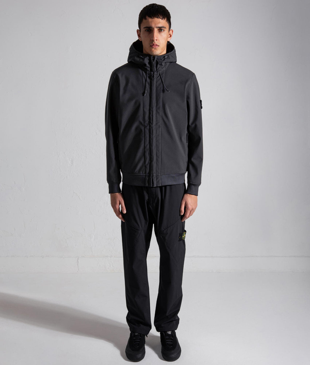 Stone Island Soft Shell-R_E DYE® Technology Jacket in Black at EQVVS Menswear. Model front shot.