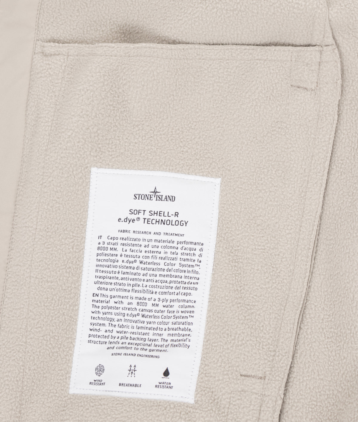 Stone Island Soft Shell-R_E.Dye® Technology Jacket in sand at EQVVS Menswear. Label shot.