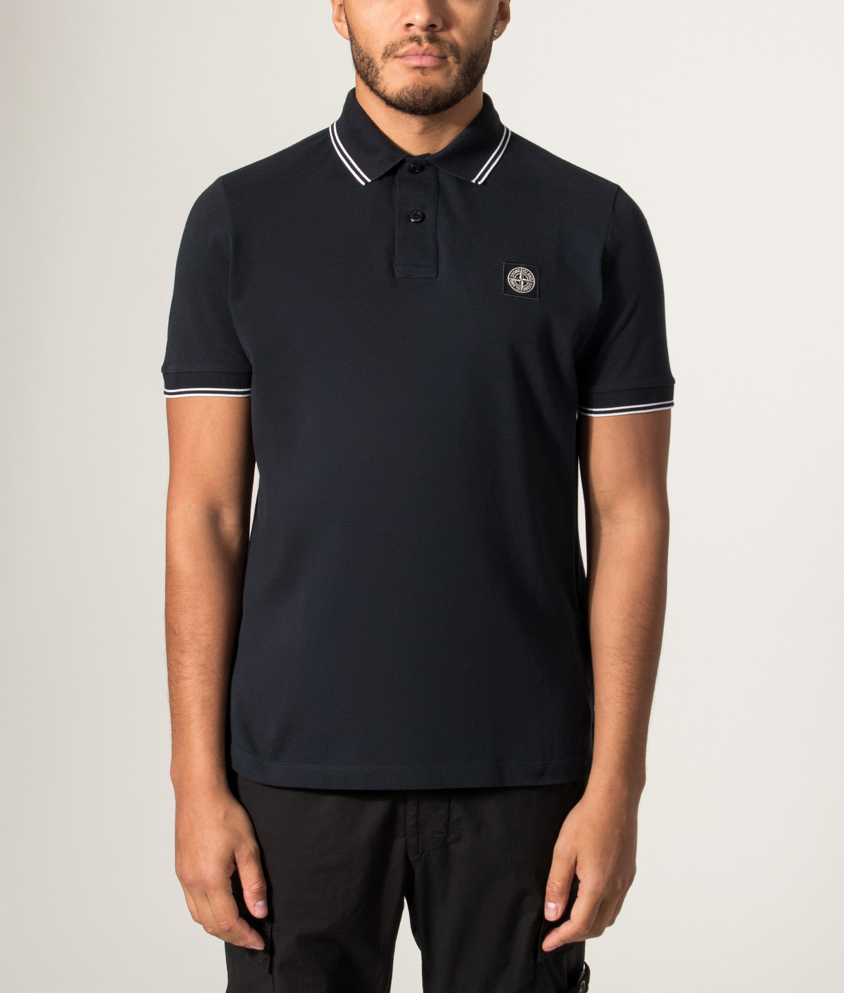 Stone Island Slim Fit Organic Cotton Polo Shirt in Navy Blue at EQVVS Menswear. Model front shot.