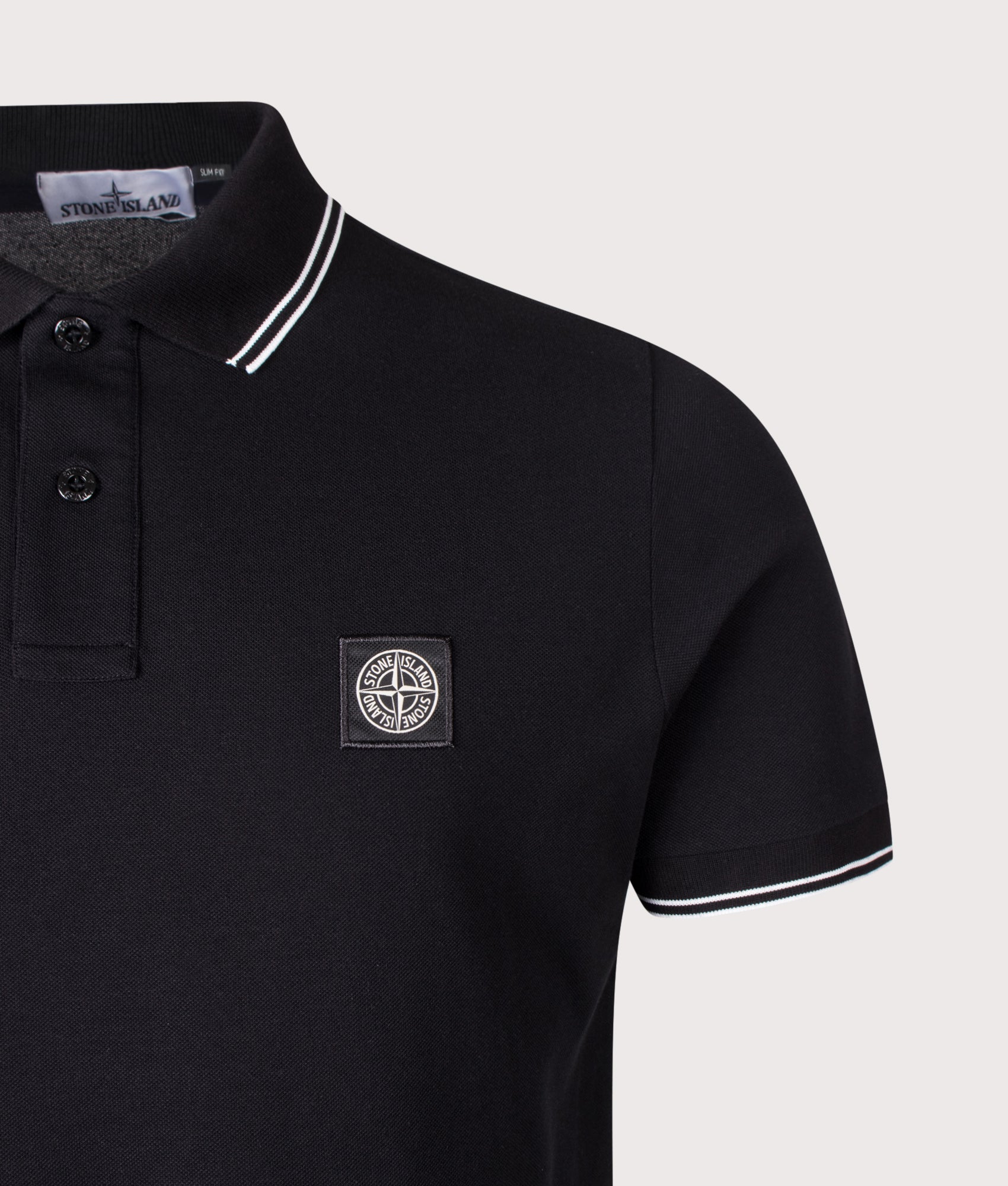 Stone Island Slim Fit Organic Cotton Polo Shirt in Black at EQVVS Menswear. Detail shot.