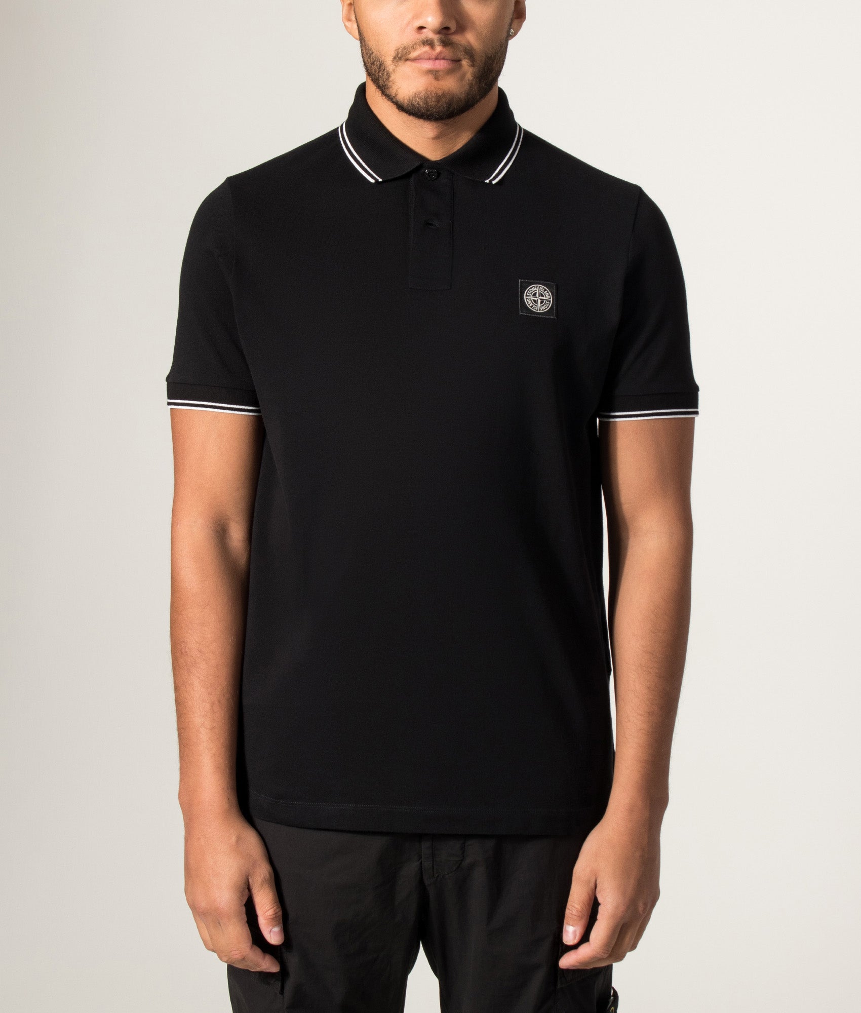 Stone Island Slim Fit Organic Cotton Polo Shirt in Black at EQVVS Menswear. Model front shot.