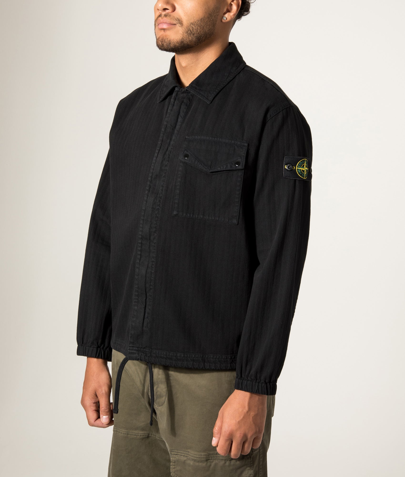Stone Island Organic Cotton Twill Overshirt in Black at EQVVS Menswear. Angled model front shot.
