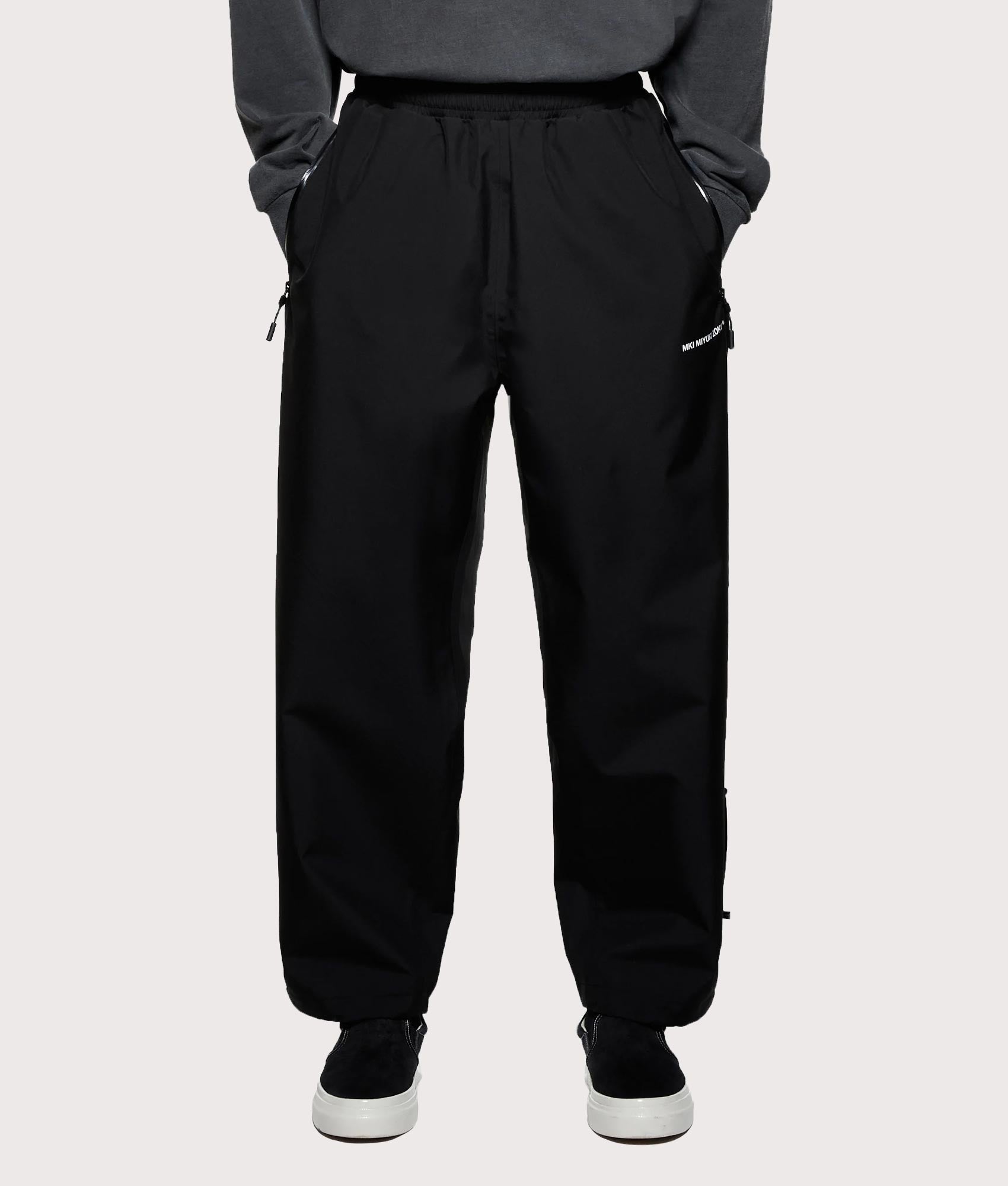 MKI MIYUKI ZOKU V3 Shell Track Pants  in Black at EQVVS Menswear. Front shot.
