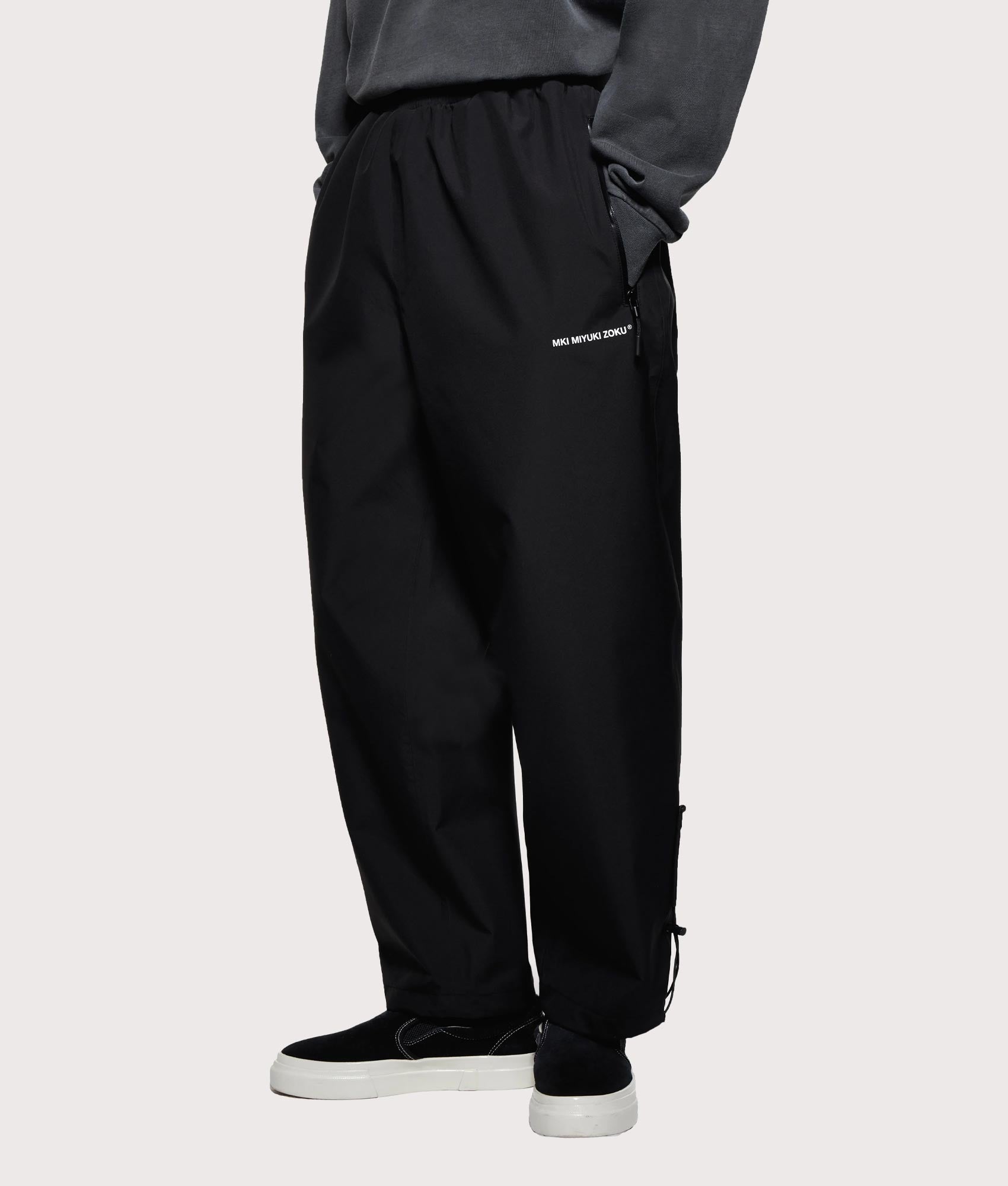 MKI MIYUKI ZOKU V3 Shell Track Pants  in Black at EQVVS Menswear. Angled front shot.