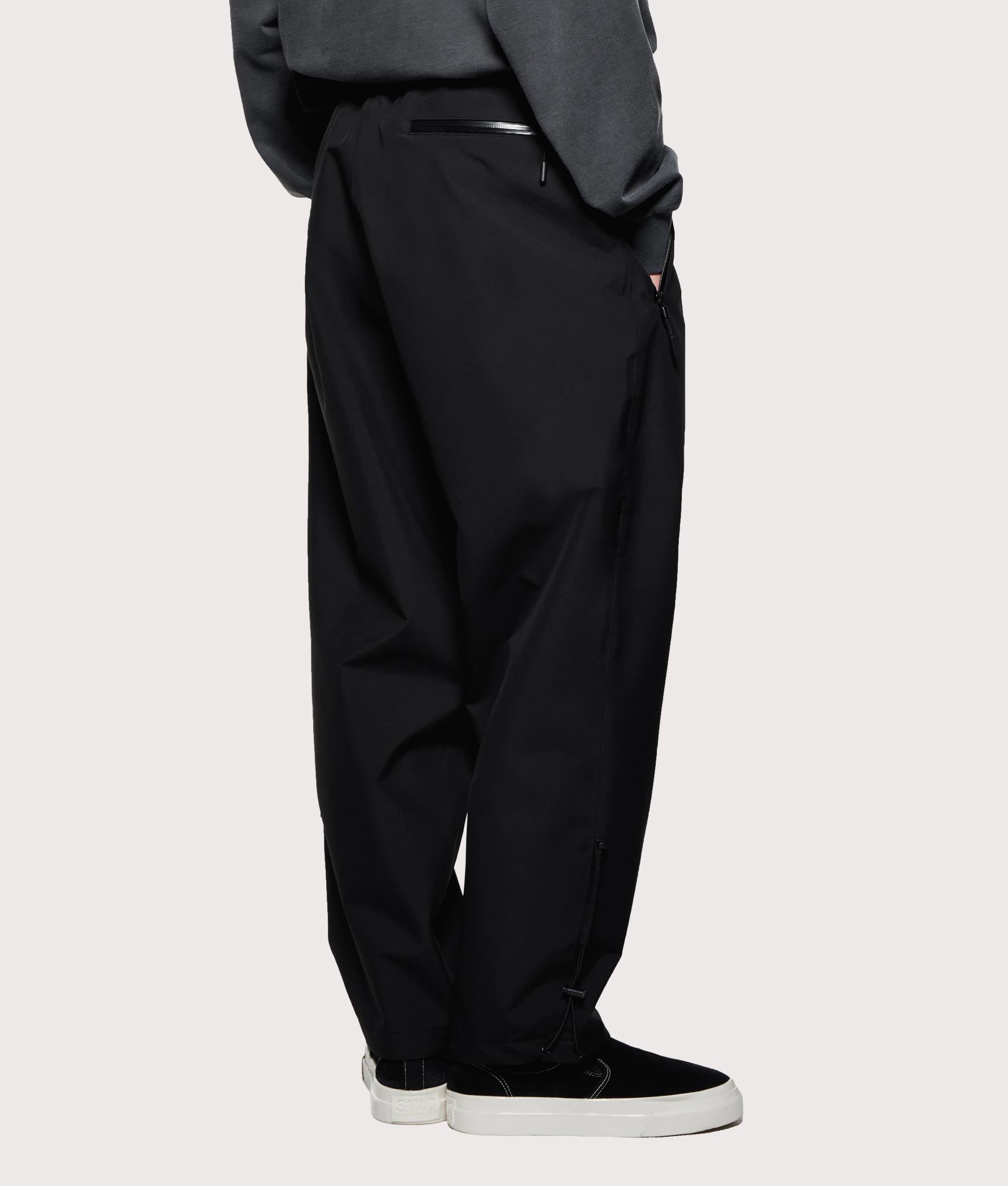 MKI MIYUKI ZOKU V3 Shell Track Pants  in Black at EQVVS Menswear. Angled back shot.