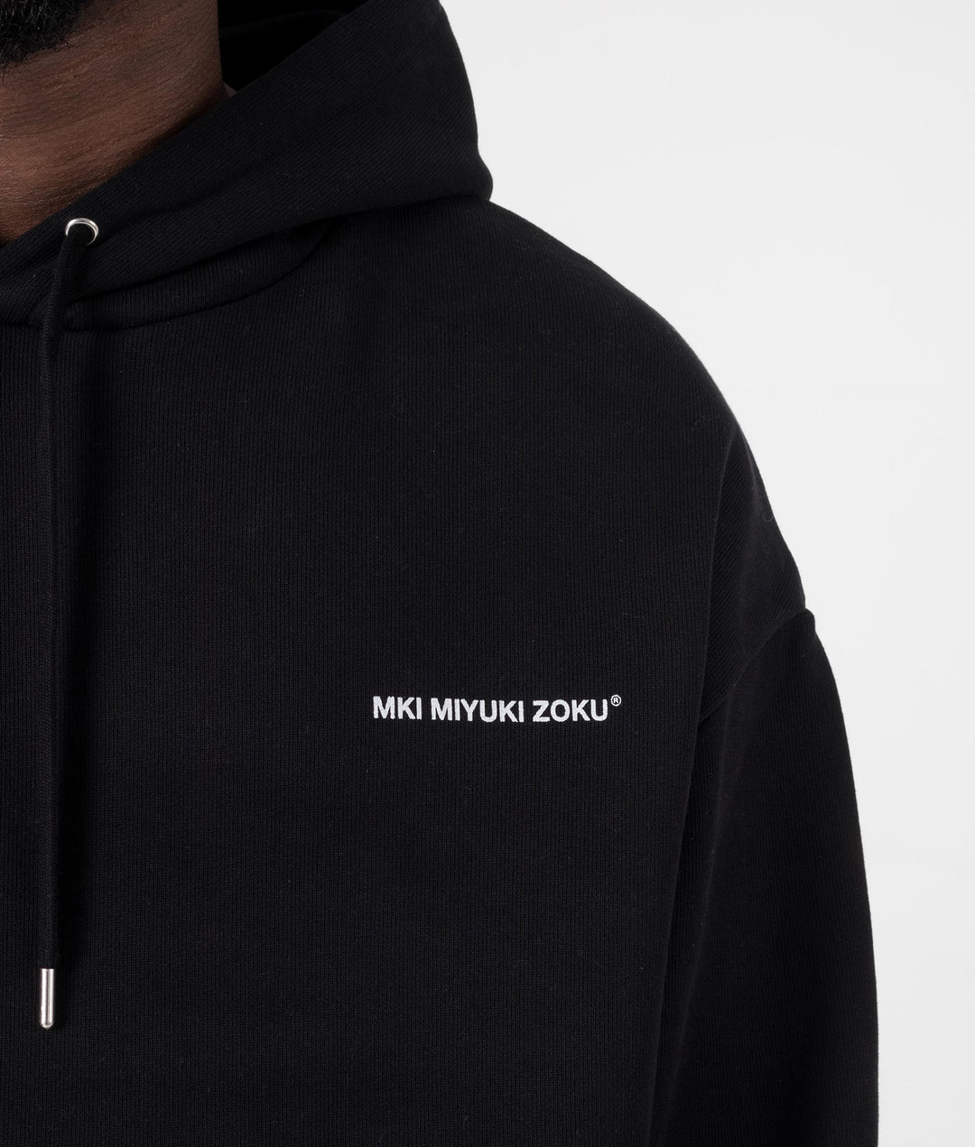 MKI MIYUKI ZOKU Oversized Uniform Hoodie in black at EQVVS Menswear. Model detail shot.