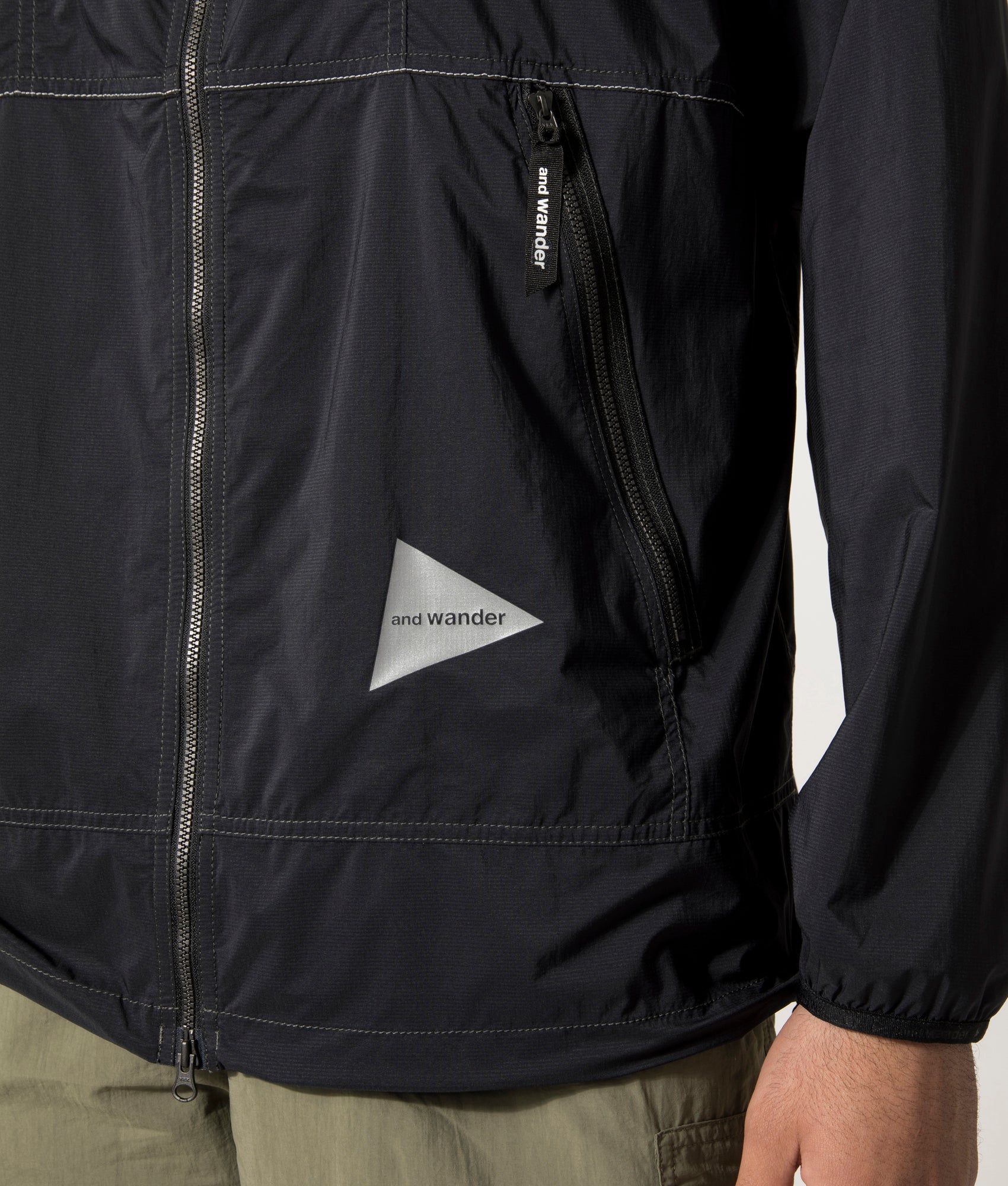 and wander Pertex Wind Jacket in Black at EQVVS. Detail Model Shot.