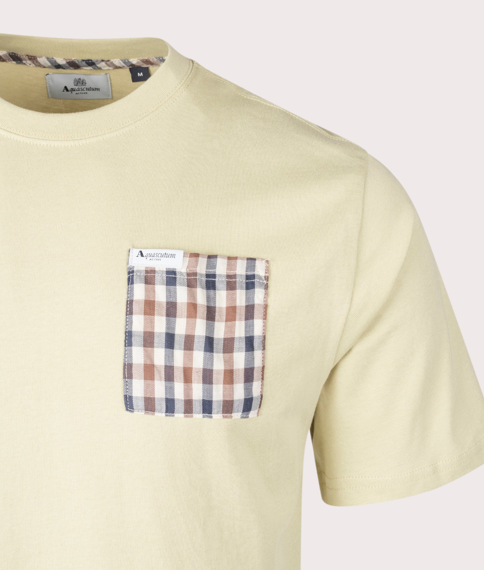 Aquascutum Club Check Pocket T-Shirt in Beige, 100% cotton at EQVVS. Detailed logo shot. 