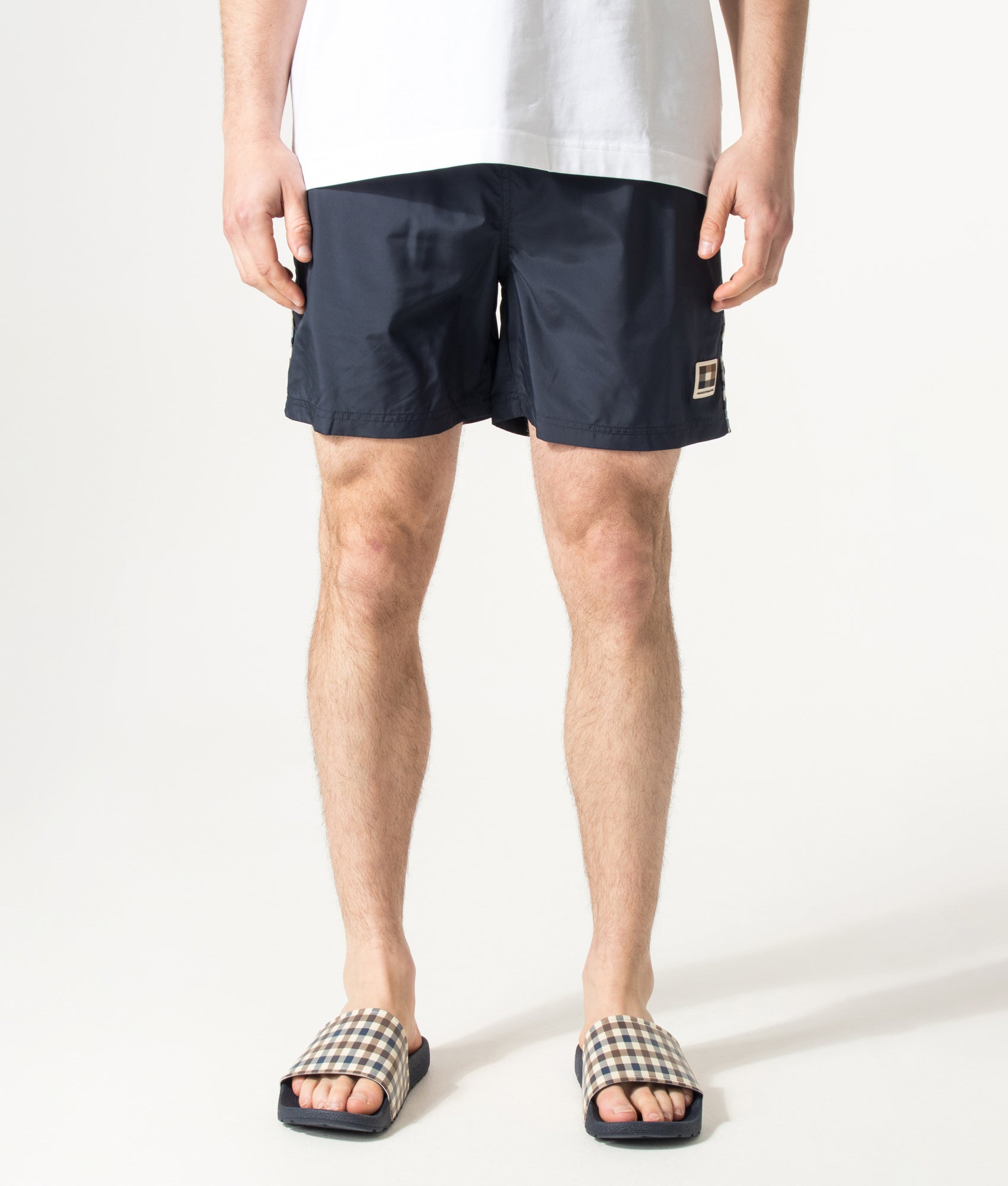 Aquascutum Club Check Piping Beach Swim Shorts in Navy at EQVVS Menswear. Model front shot.