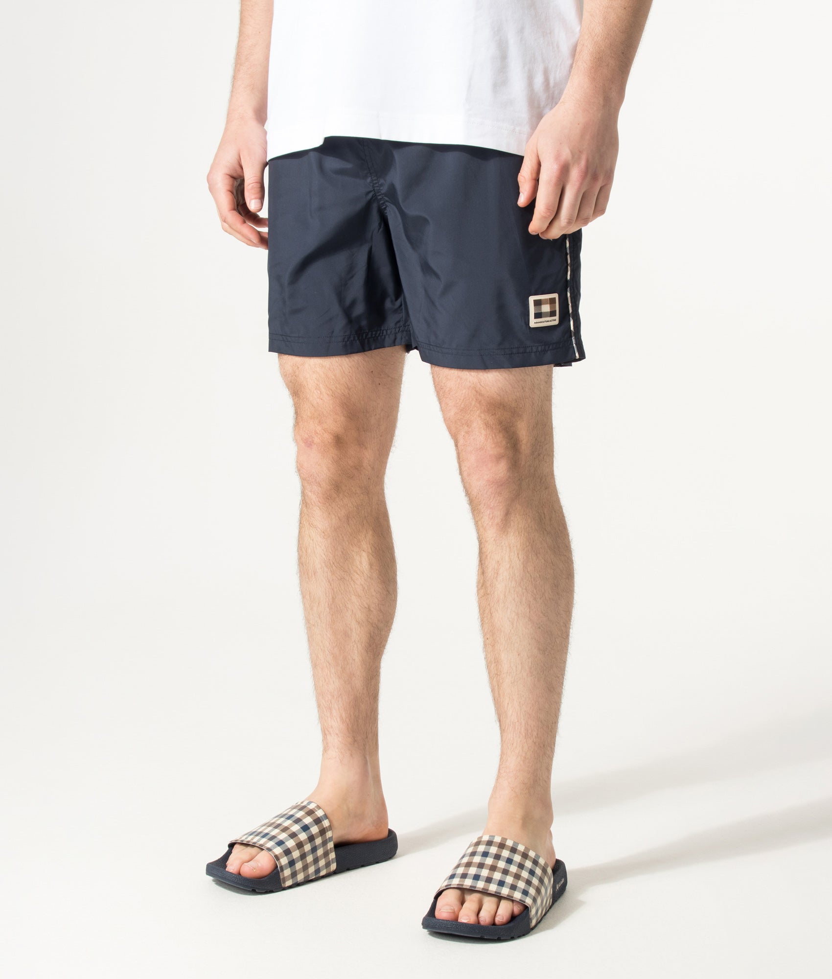 Aquascutum Club Check Piping Beach Swim Shorts in Navy at EQVVS Menswear. Angled model front shot.