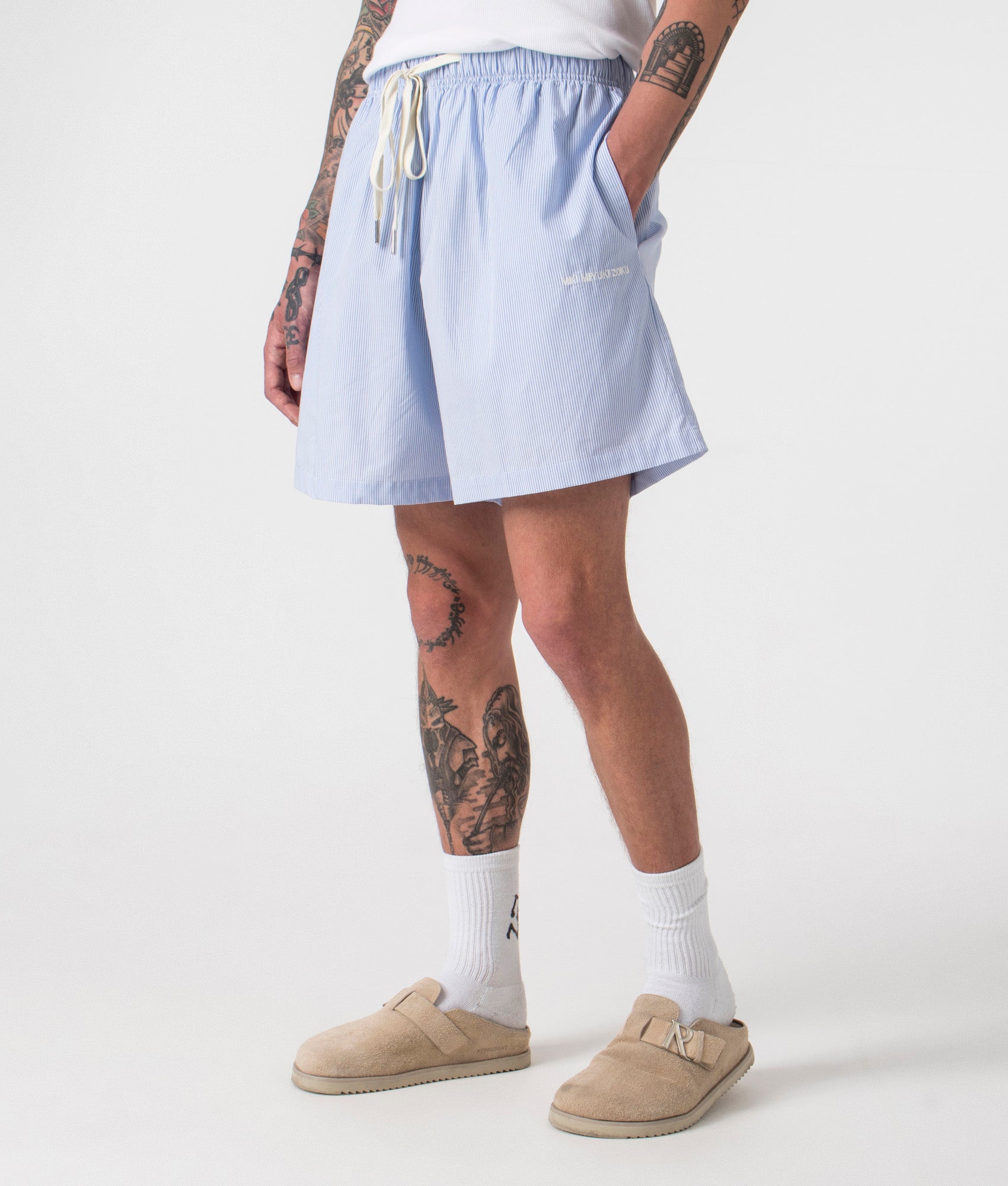 Relaxed Fit Striped Shorts in Blue by MKI MIYUKI ZOKU. EQVVS Side Angle Model Shot.