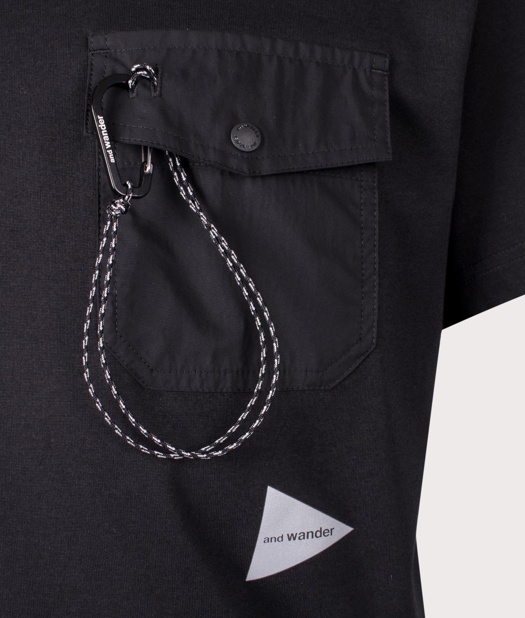 and wander Pocket T-Shirt in Black. Shot at EQVVS. Front logo shot 