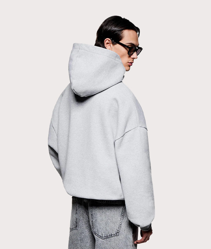 MKI MIYUKI ZOKU Oversized Arch Hoodie in Grey at EQVVS Menswear.  Angled model back shot.