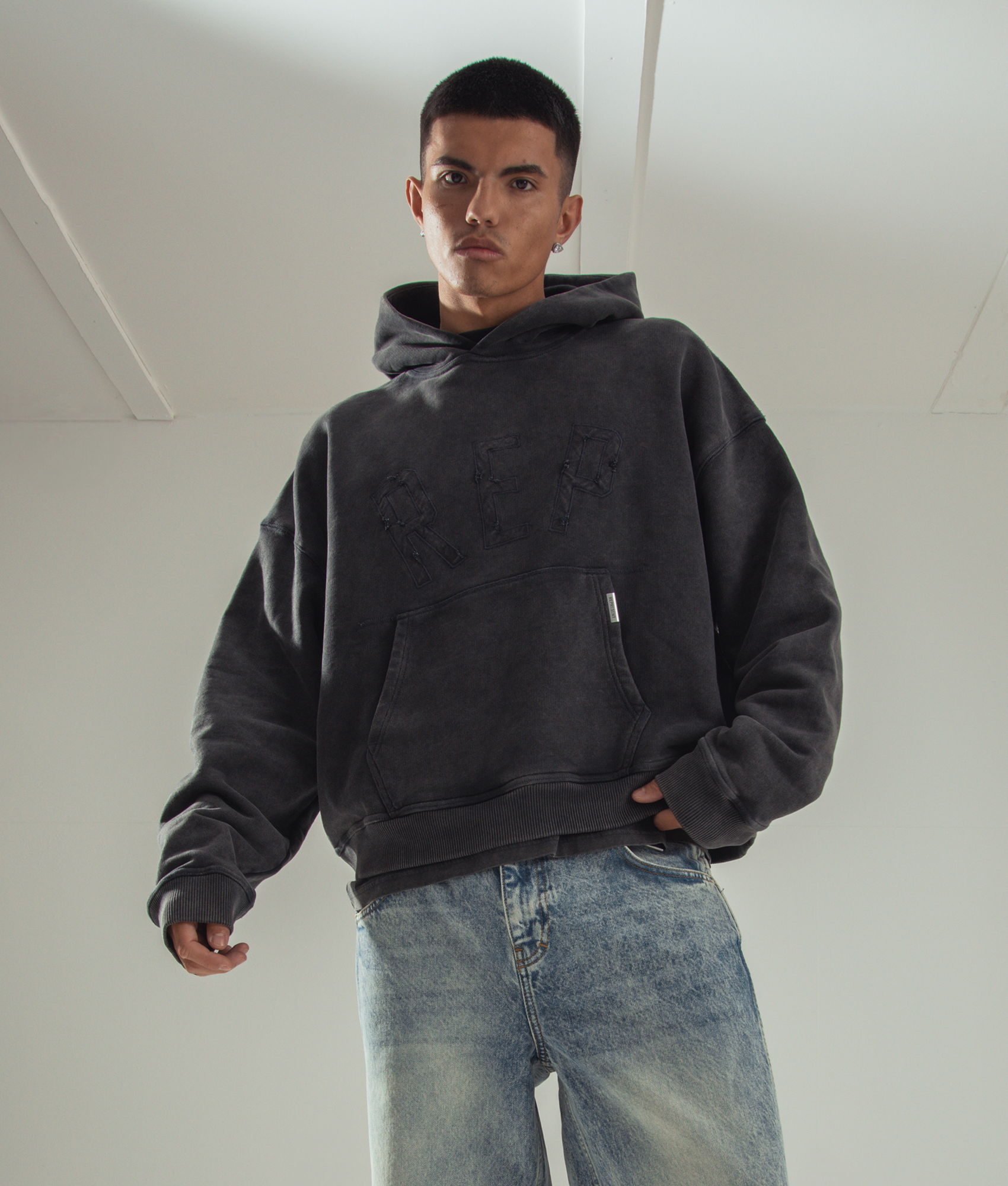 Rep Applique Hoodie in Vintage Black by Represent. EQVVS campaign Shot. 