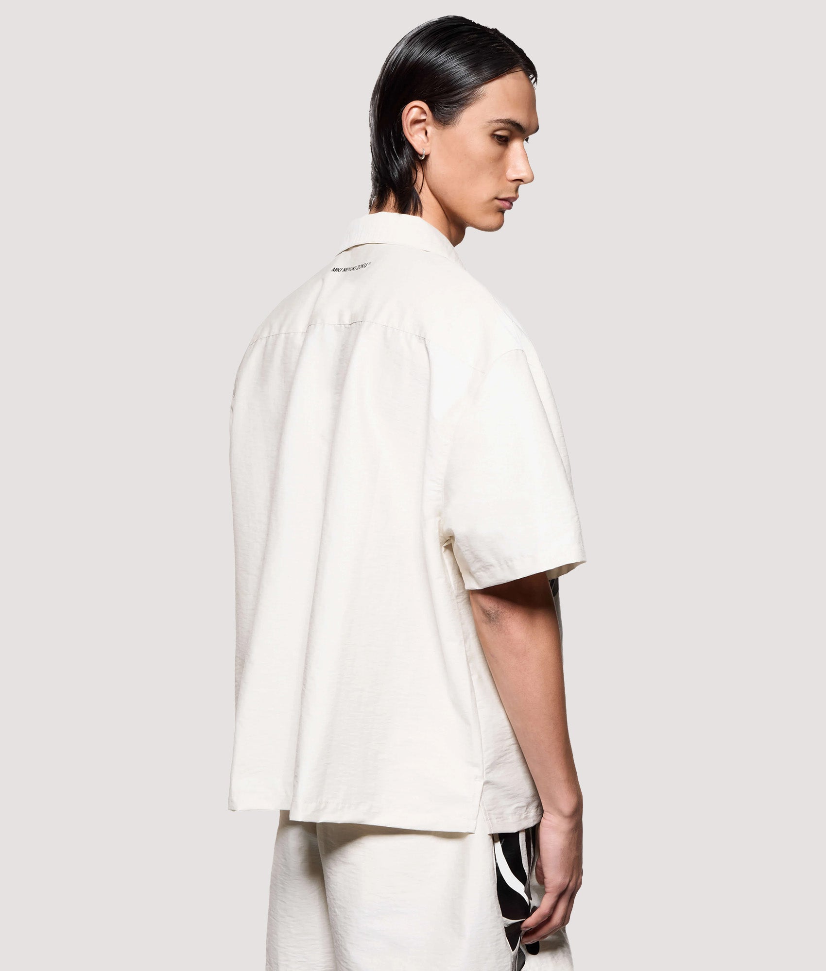 MKI MIYUKI ZOKU Box Fit Botanical Print Short Sleeve Vacation Shirt in Bone. Model angled back shot.