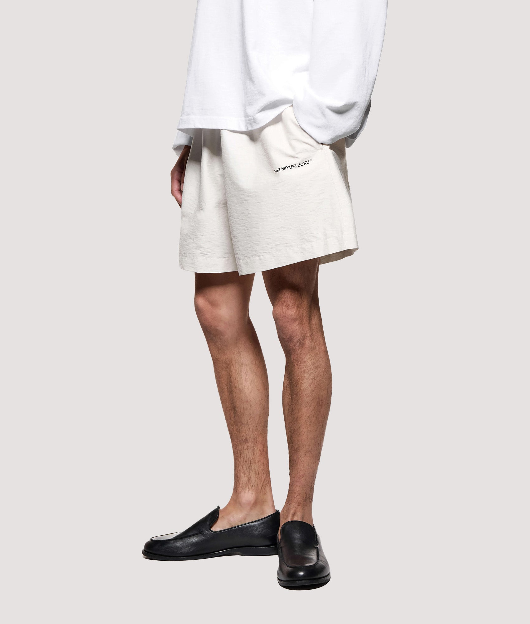 MKI MIYUKI ZOKU Relaxed Fit Botanical Print Wide Leg Shorts in Bone at EQVVS Menswear. Model front shot.
