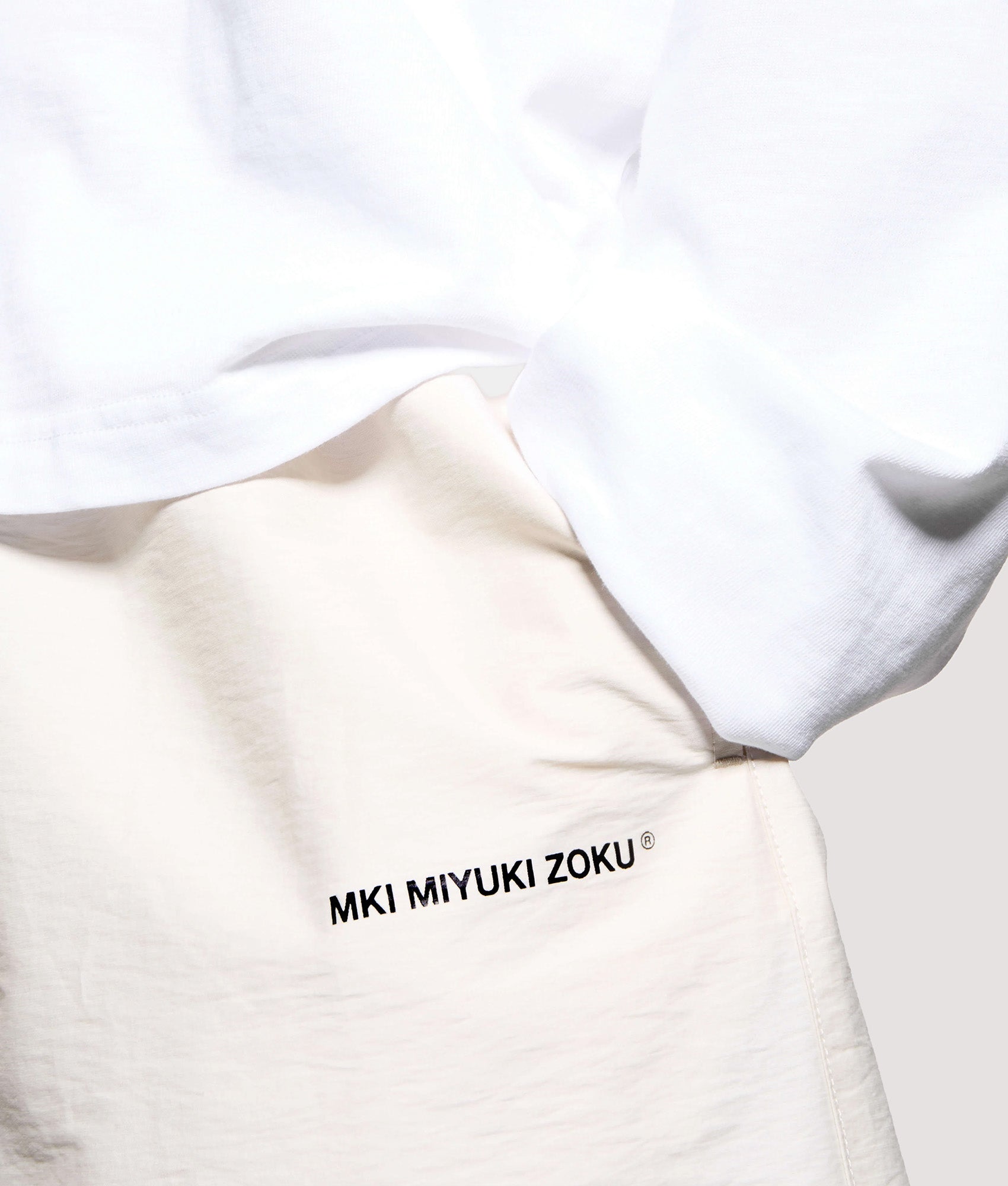 MKI MIYUKI ZOKU Relaxed Fit Botanical Print Wide Leg Shorts in Bone at EQVVS Menswear. Detail shot.
