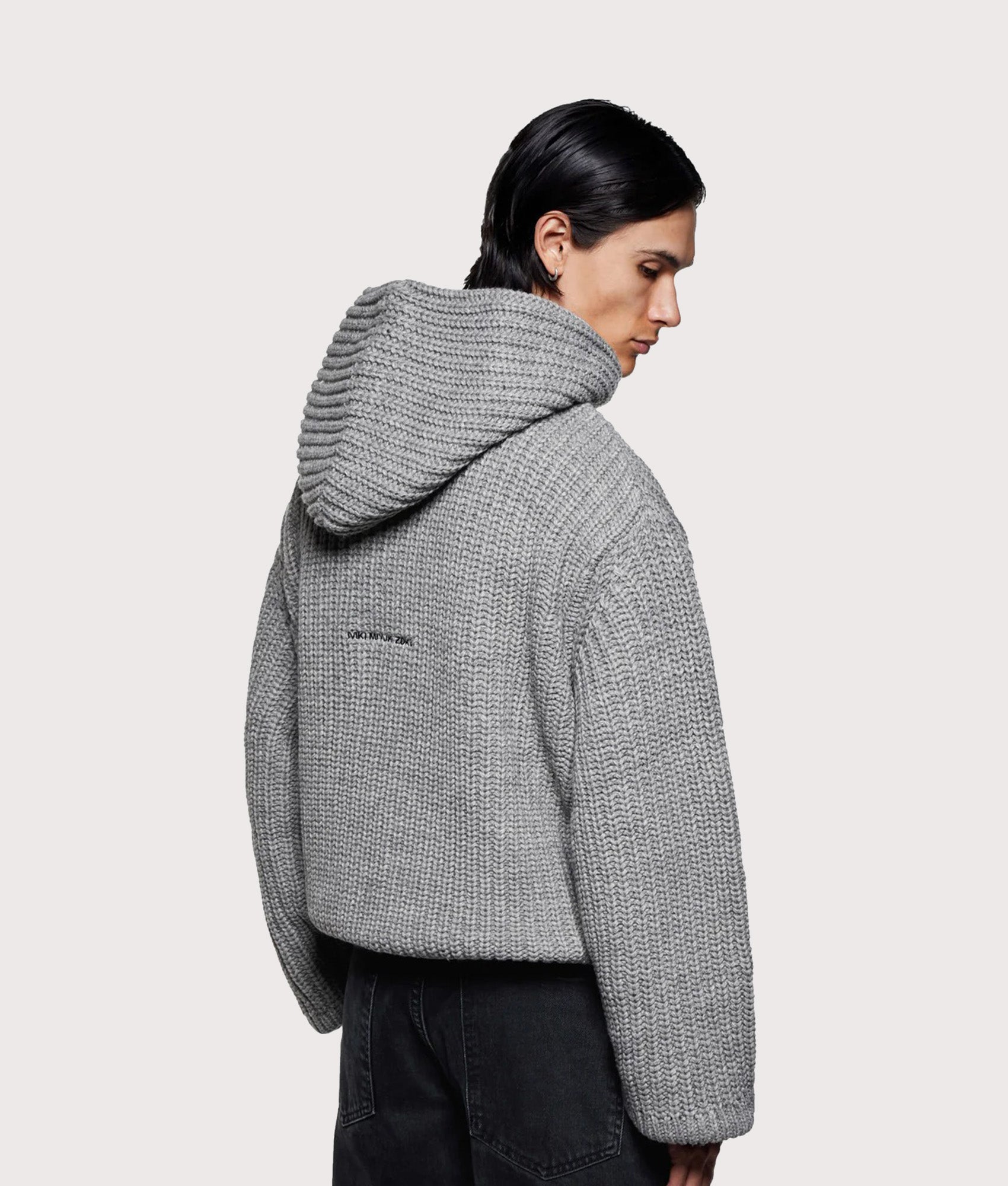 MKI MIYUKI ZOKU Oversized Chunky Ribbed Knit Hoodie in Grey Melange at EQVVS Menswear. Angled model back shot.